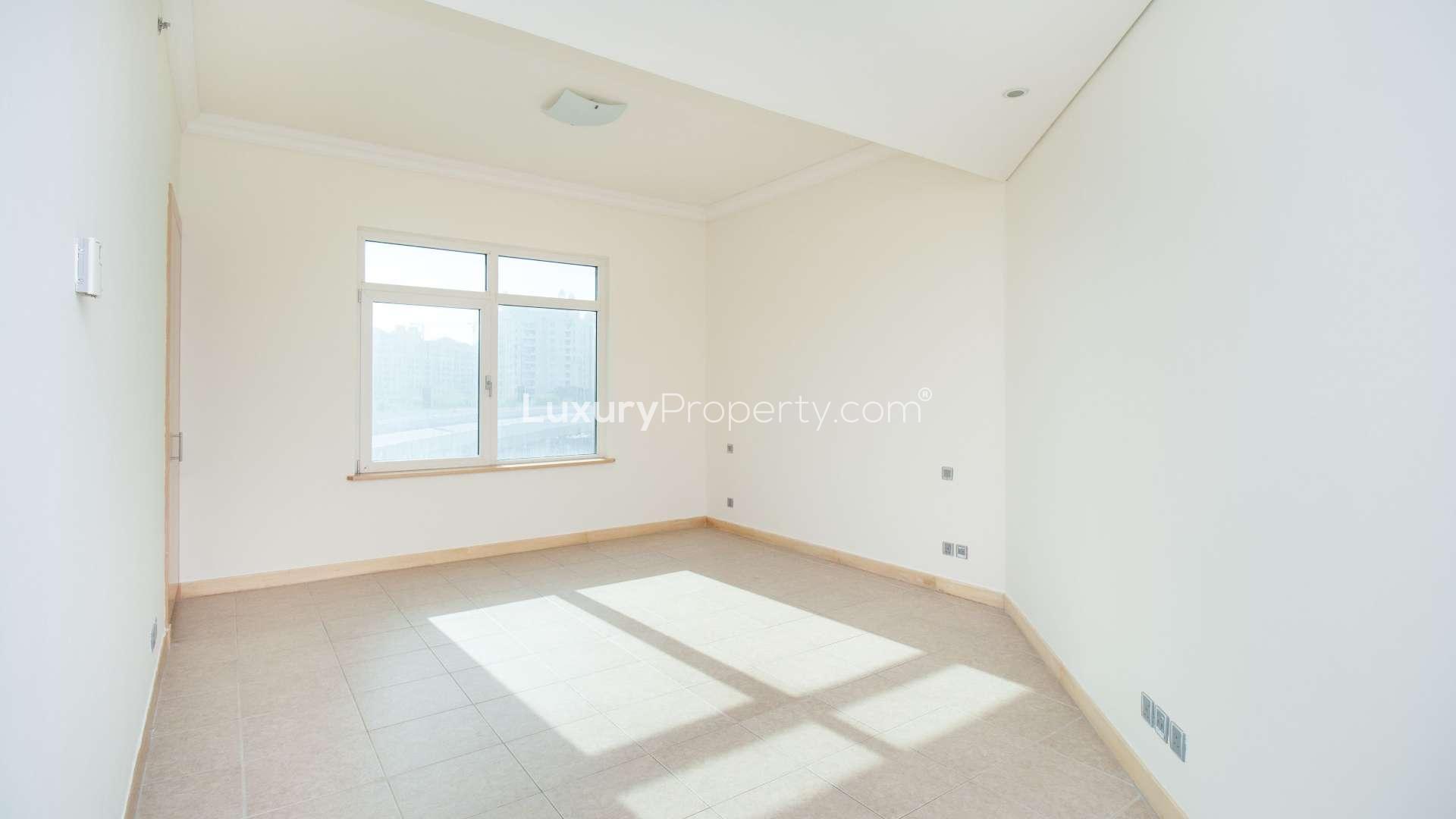 Empty room in Palm Jumeirah apartment, large window, bright natural light, tiled floor
