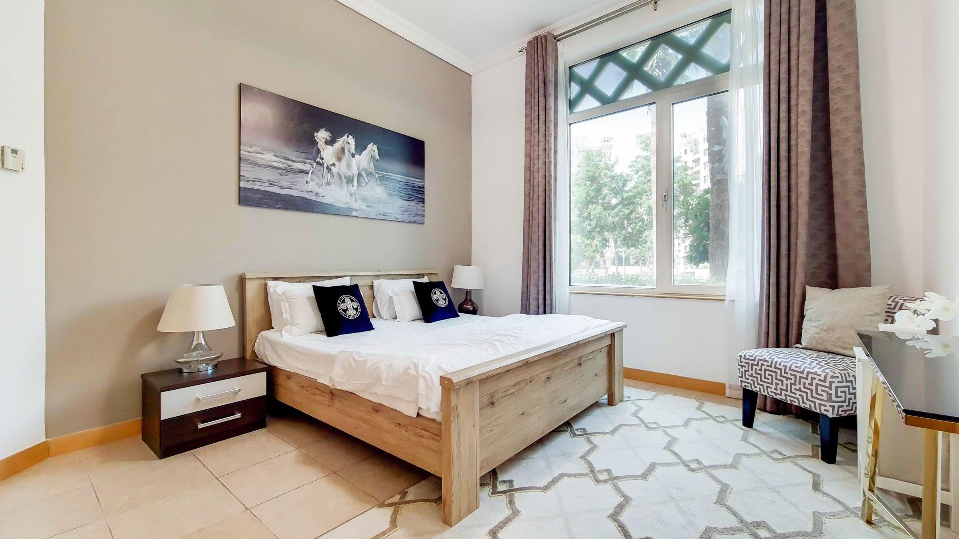 Spacious living room in Palm Jumeirah Shoreline Apartments, featuring elegant decor and chandelier
