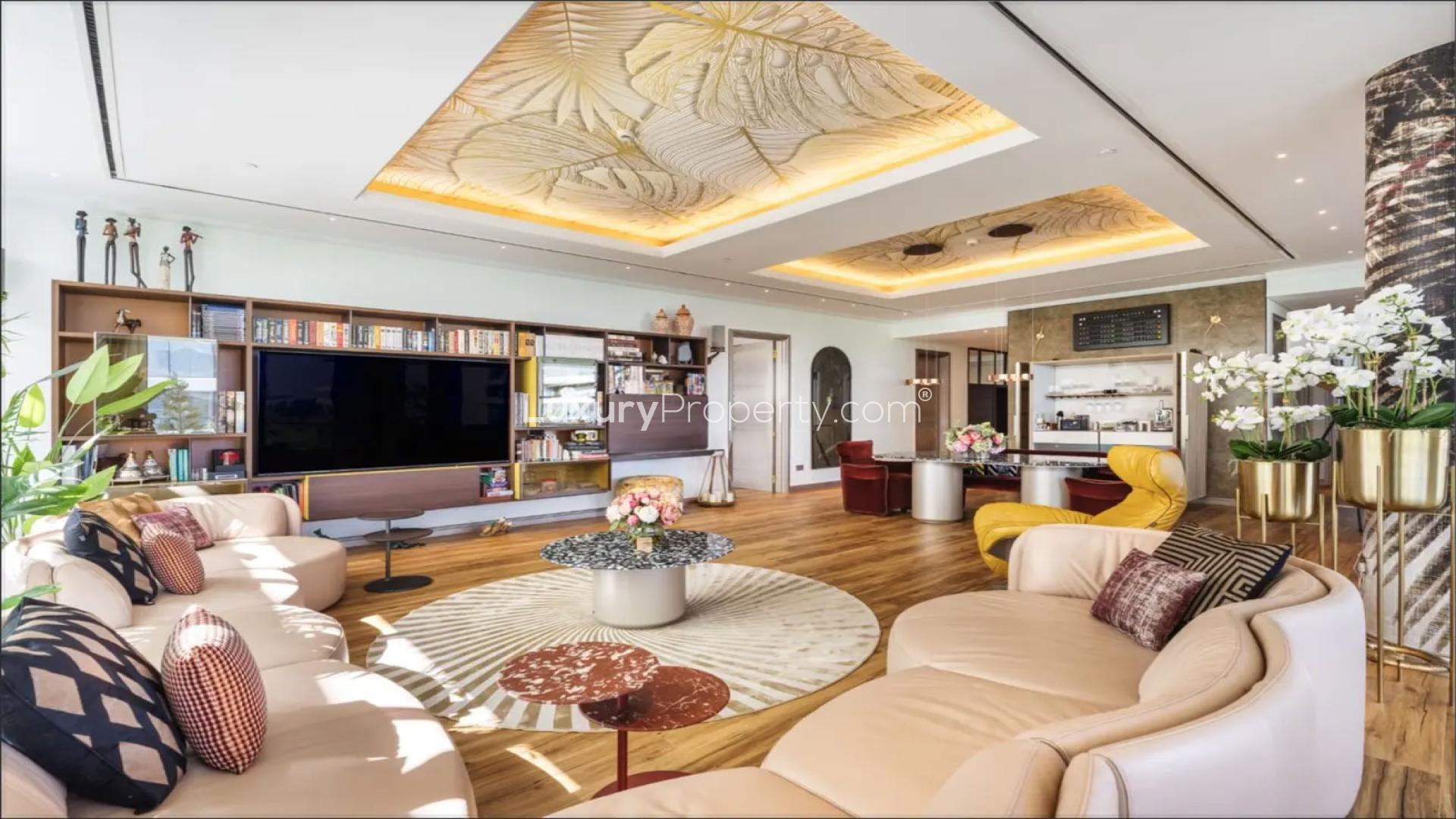 Modern kitchen in Al Barari Ashjar apartment, featuring marble island and wooden cabinetry