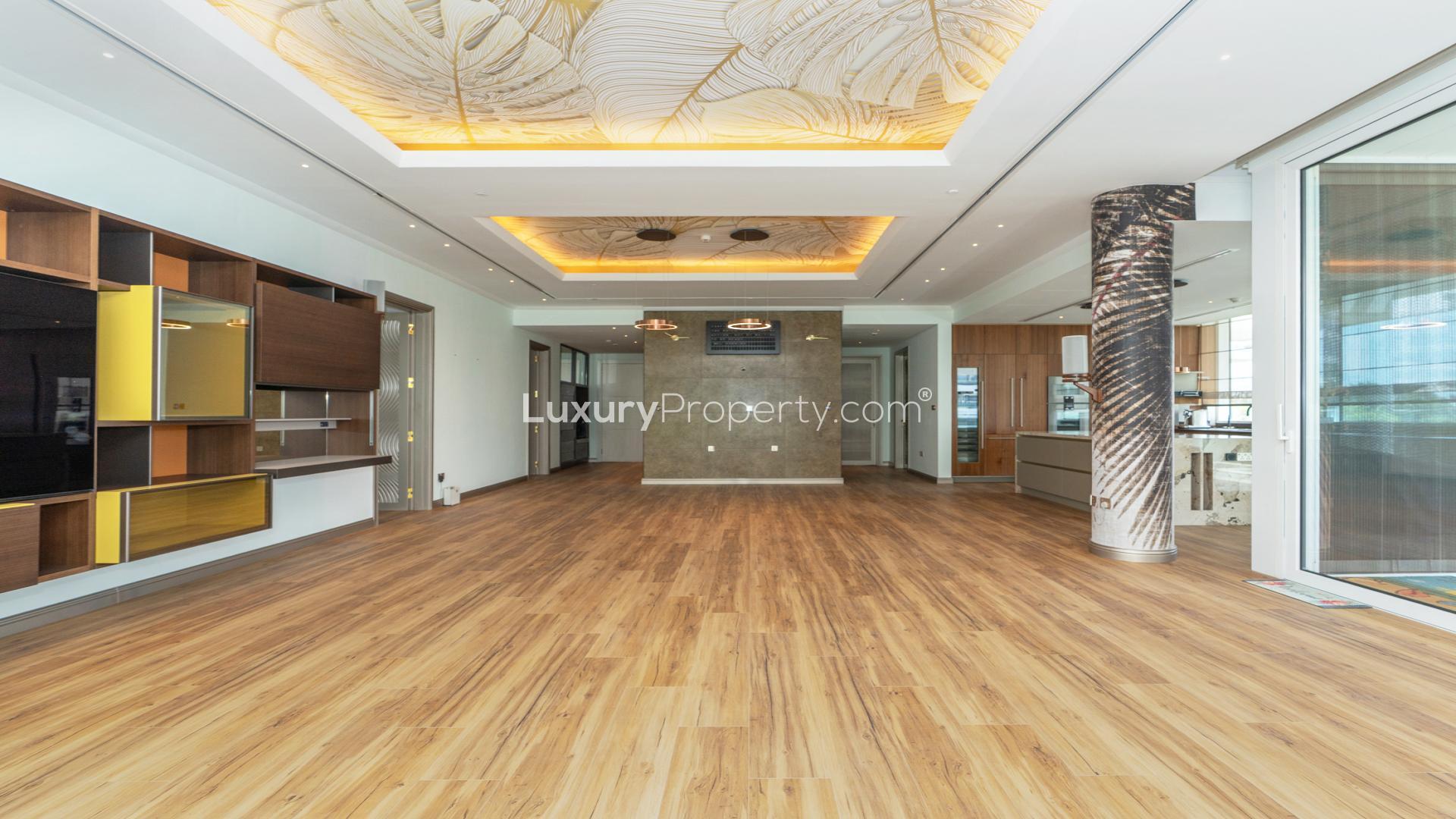 Spacious modern living room with wooden floors and large windows in Al Barari apartment