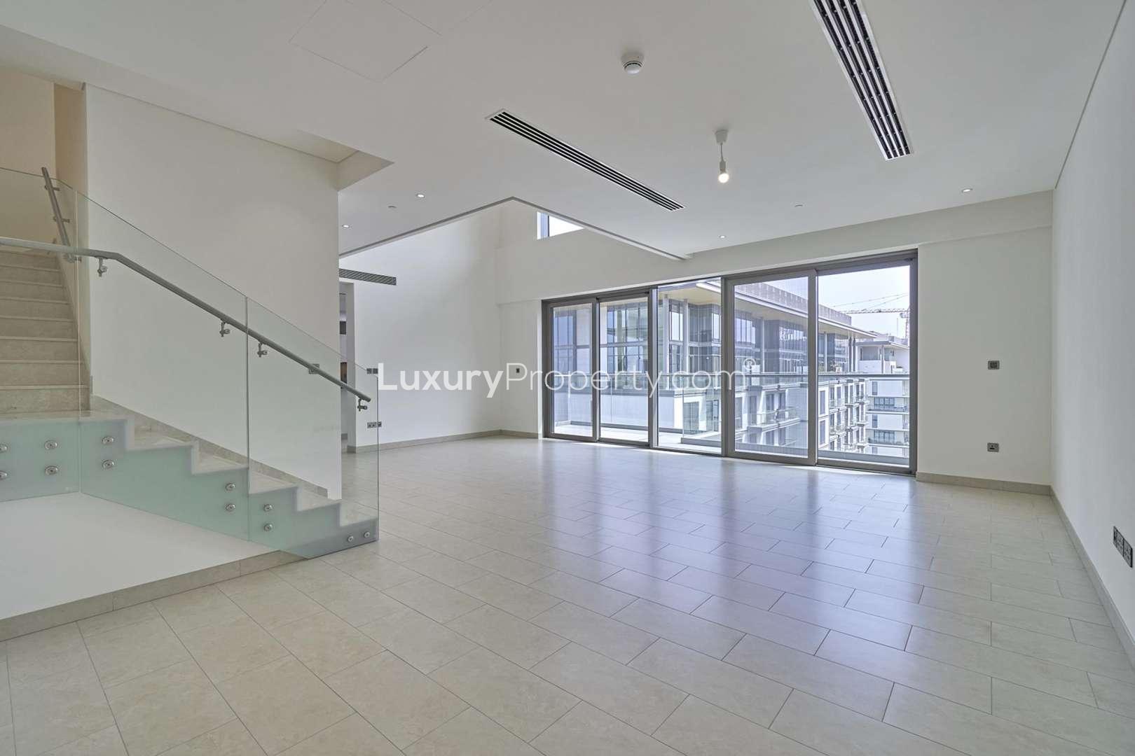 "Spacious balcony view in Hartland Greens duplex, Sobha Hartland, Mohammed Bin Rashid City.",Spacious living area in three-bedroom duplex, Sobha Hartland, with large windows and staircase