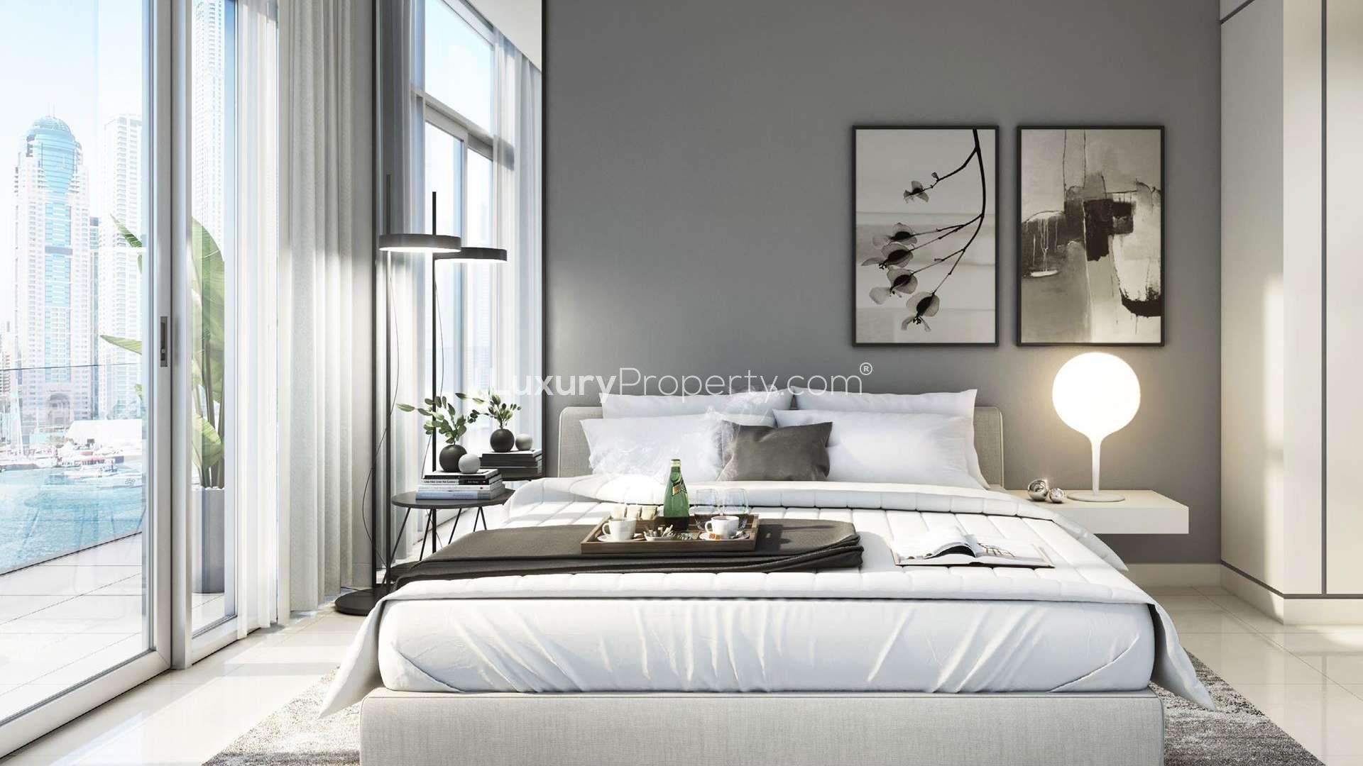 Twin high-rise apartment buildings at Emaar Beachfront, Dubai Harbour, against a stunning sunset