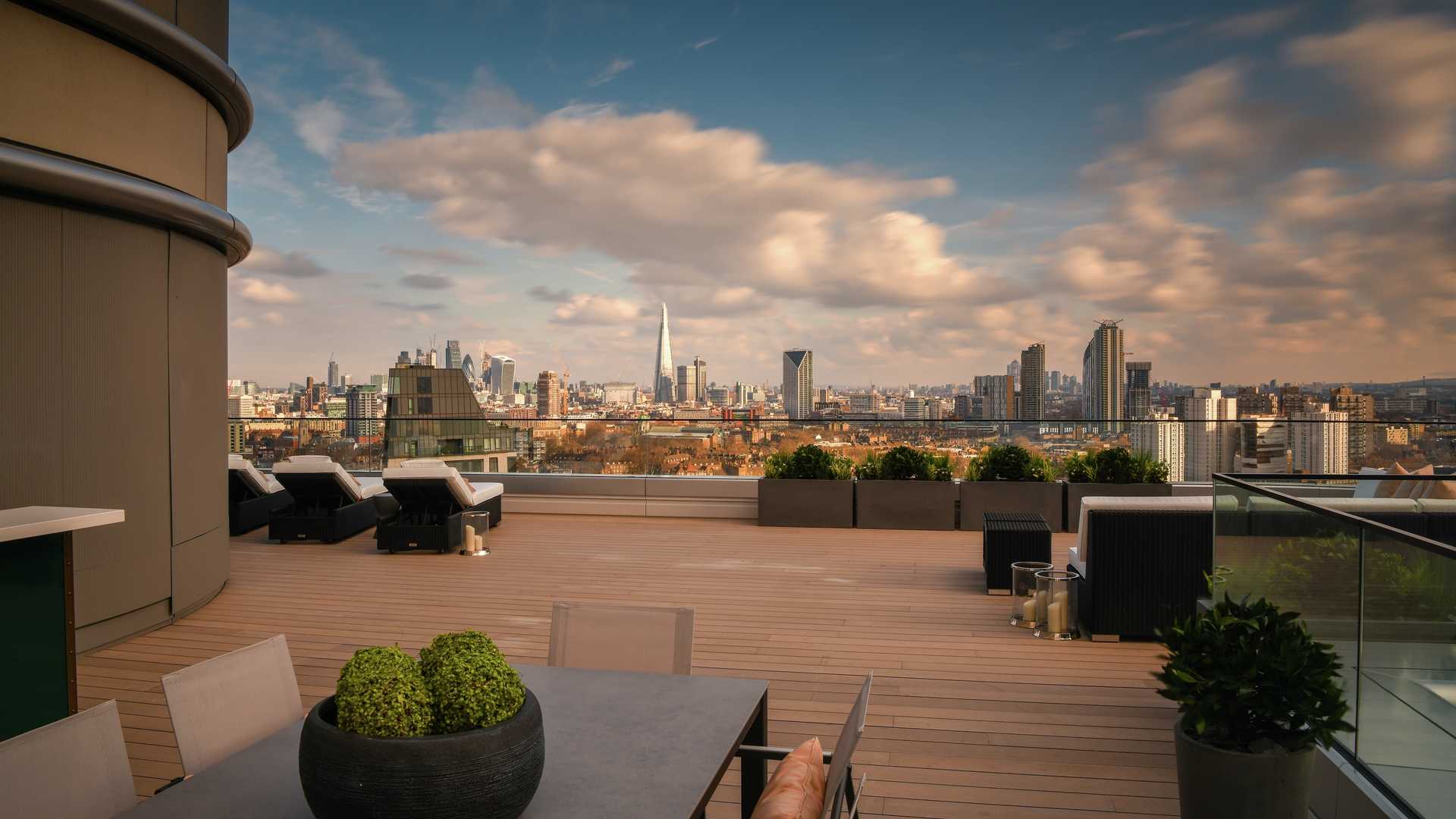 "Rooftop terrace view from The Corniche apartment, South Bank, London skyline in background.","Stunning terrace view from three-bedroom apartment at The Corniche, South Bank, London.",Luxury bedroom in The Corniche apartment, London, with stunning river views