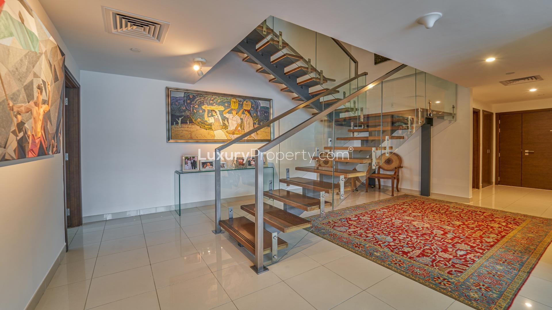 "Spacious Business Bay apartment terrace with stunning waterfront and city skyline views.",Elegant entryway with modern staircase in West Wharf apartment, Business Bay