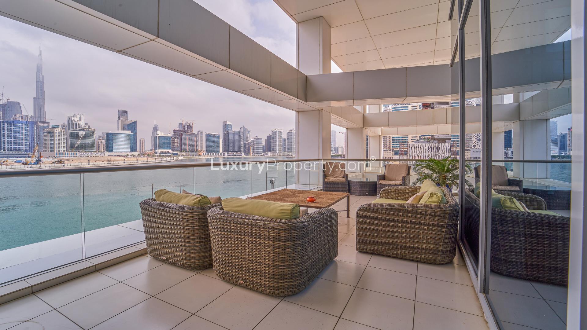 Luxurious Business Bay apartment living room with waterfront view, modern decor, and large windows