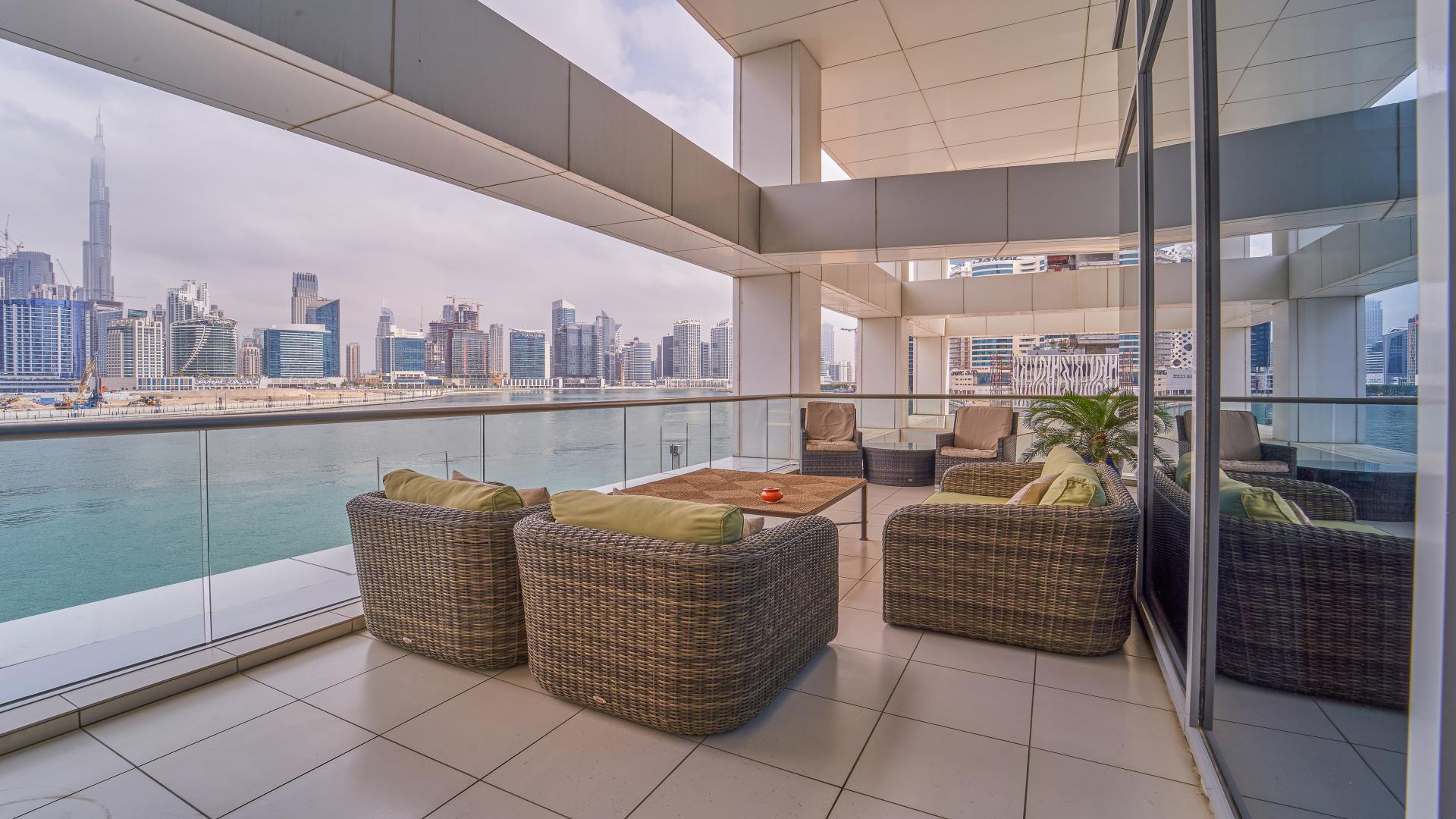 Luxurious Business Bay apartment living room with waterfront view, modern decor, and large windows