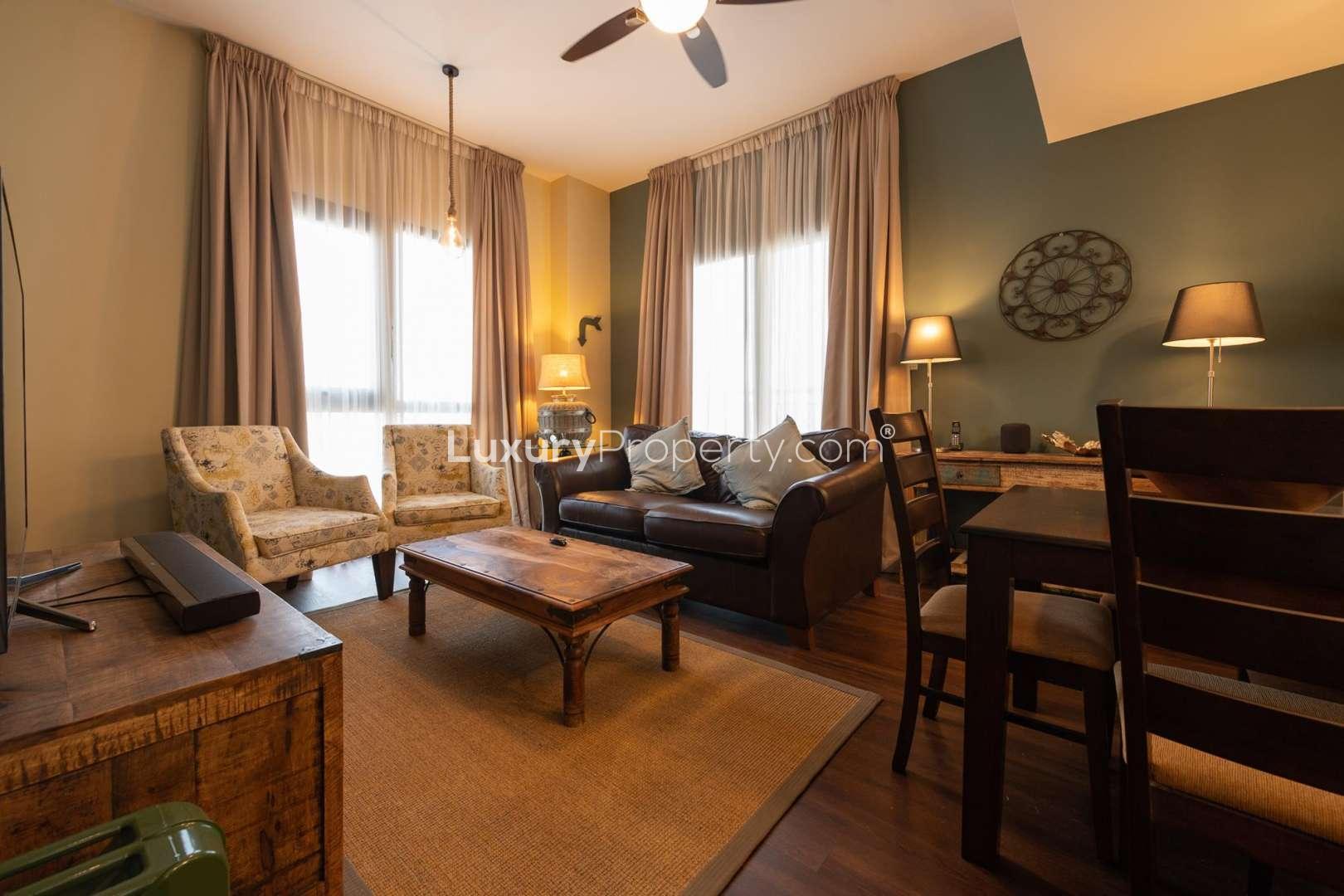 Balcony view of Zahra Apartments, Town Square, overlooking modern buildings and palm-lined street