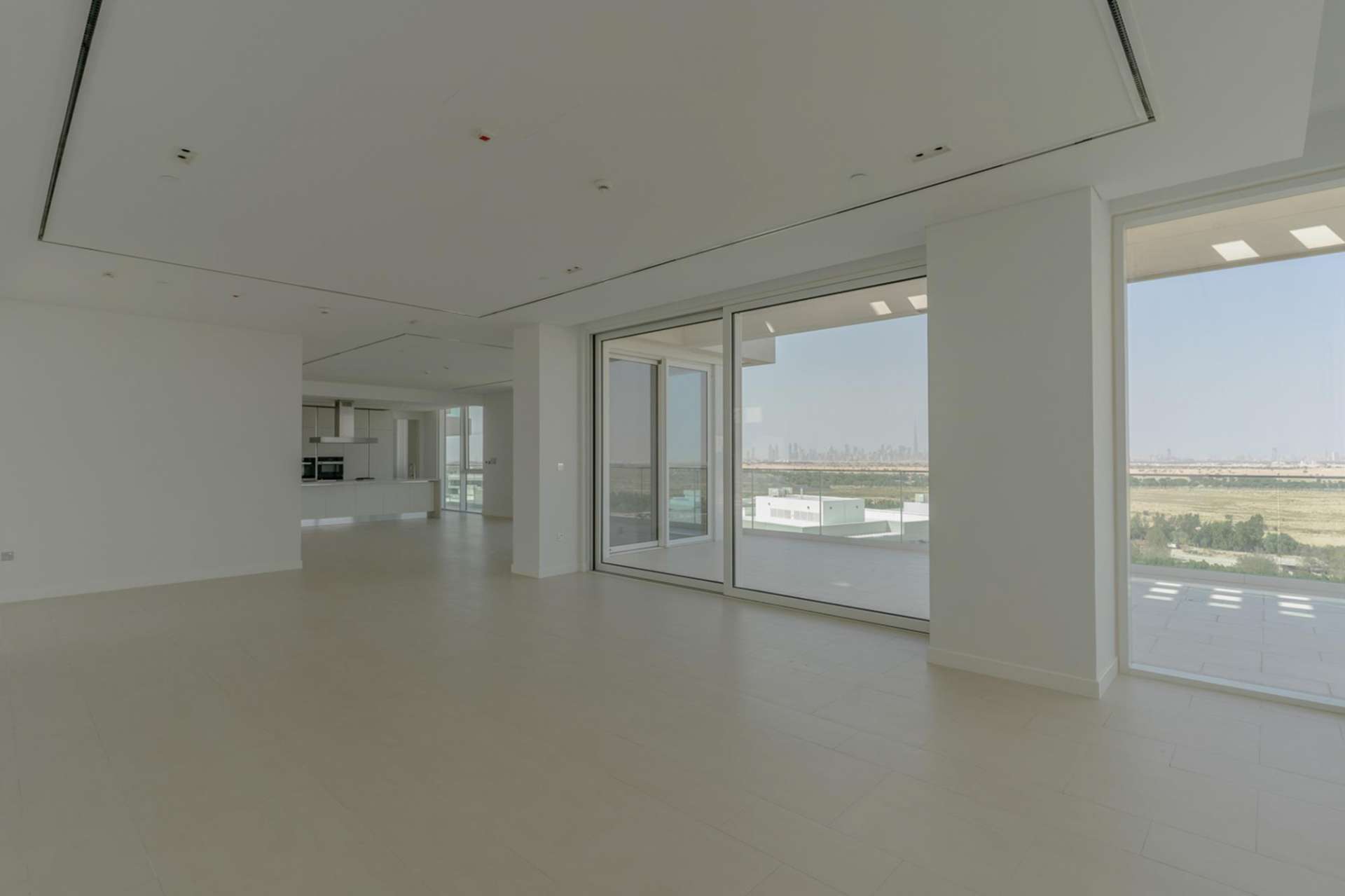 Empty room with large window view in Al Barari Seventh Heaven penthouse, Dubai