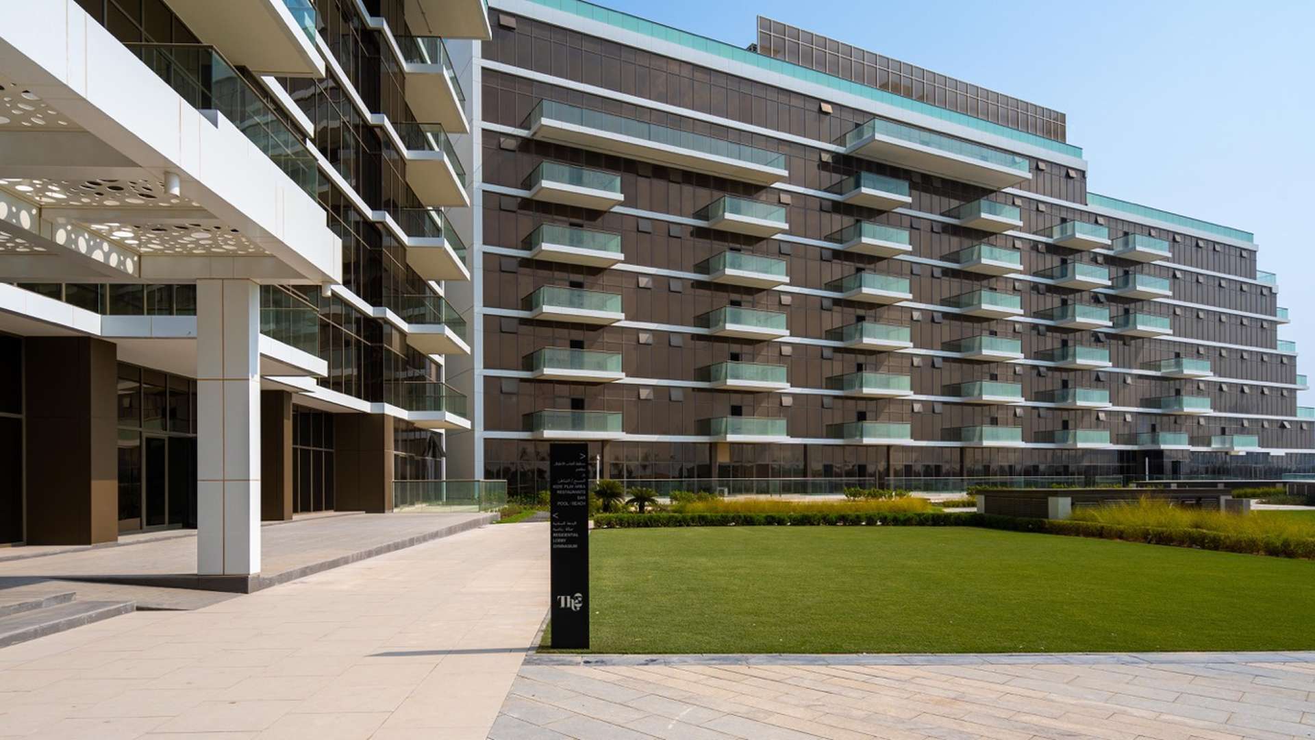 "Modern bathroom vanity in beachfront penthouse, The Palm Jumeirah, with dual sinks and mirror.",Beachfront penthouse exterior at The 8, Palm Jumeirah with modern architecture and greenery