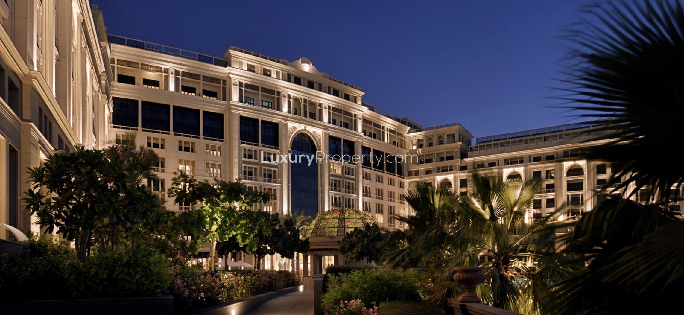 Luxurious pool area at Palazzo Versace apartment, Culture Village, with palm trees and loungers