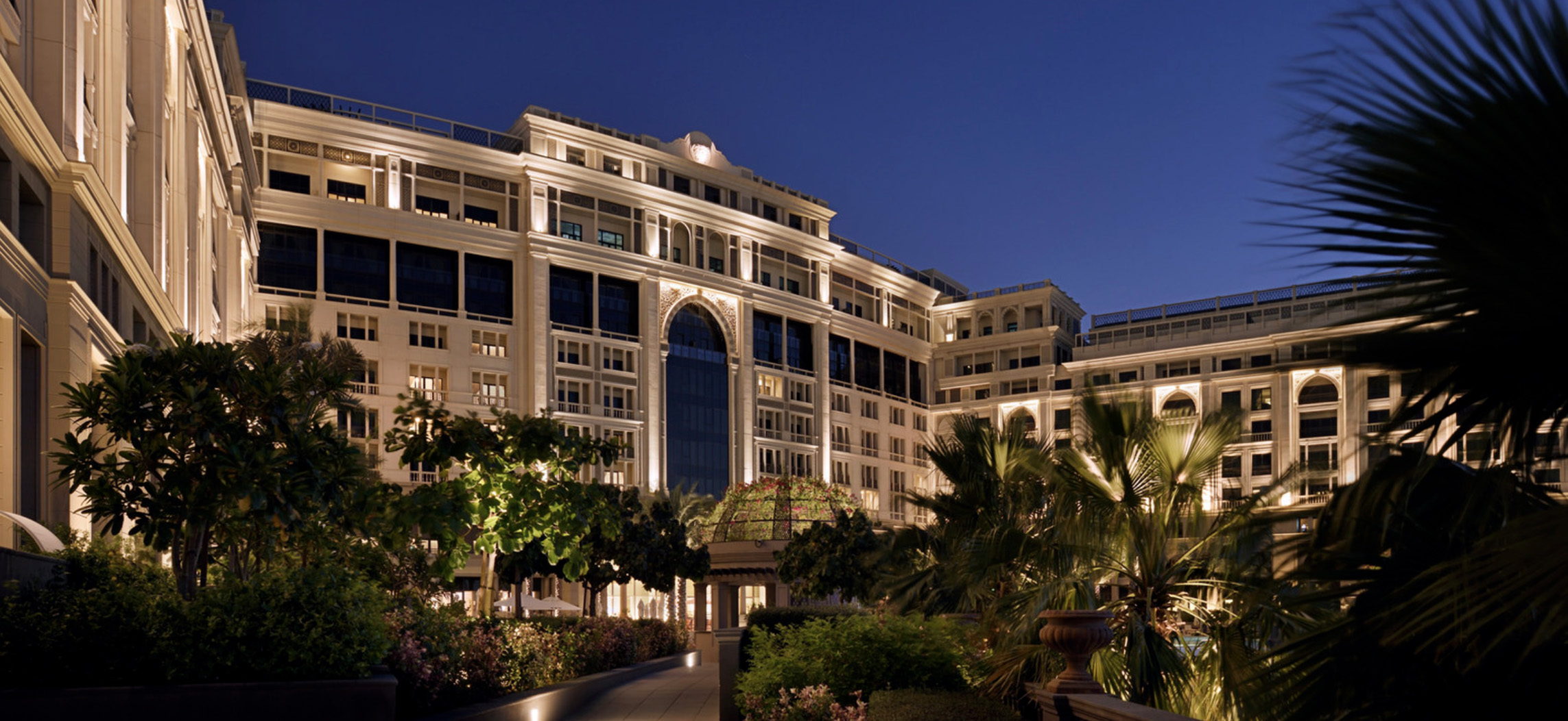 Luxurious pool area at Palazzo Versace apartment, Culture Village, with palm trees and loungers