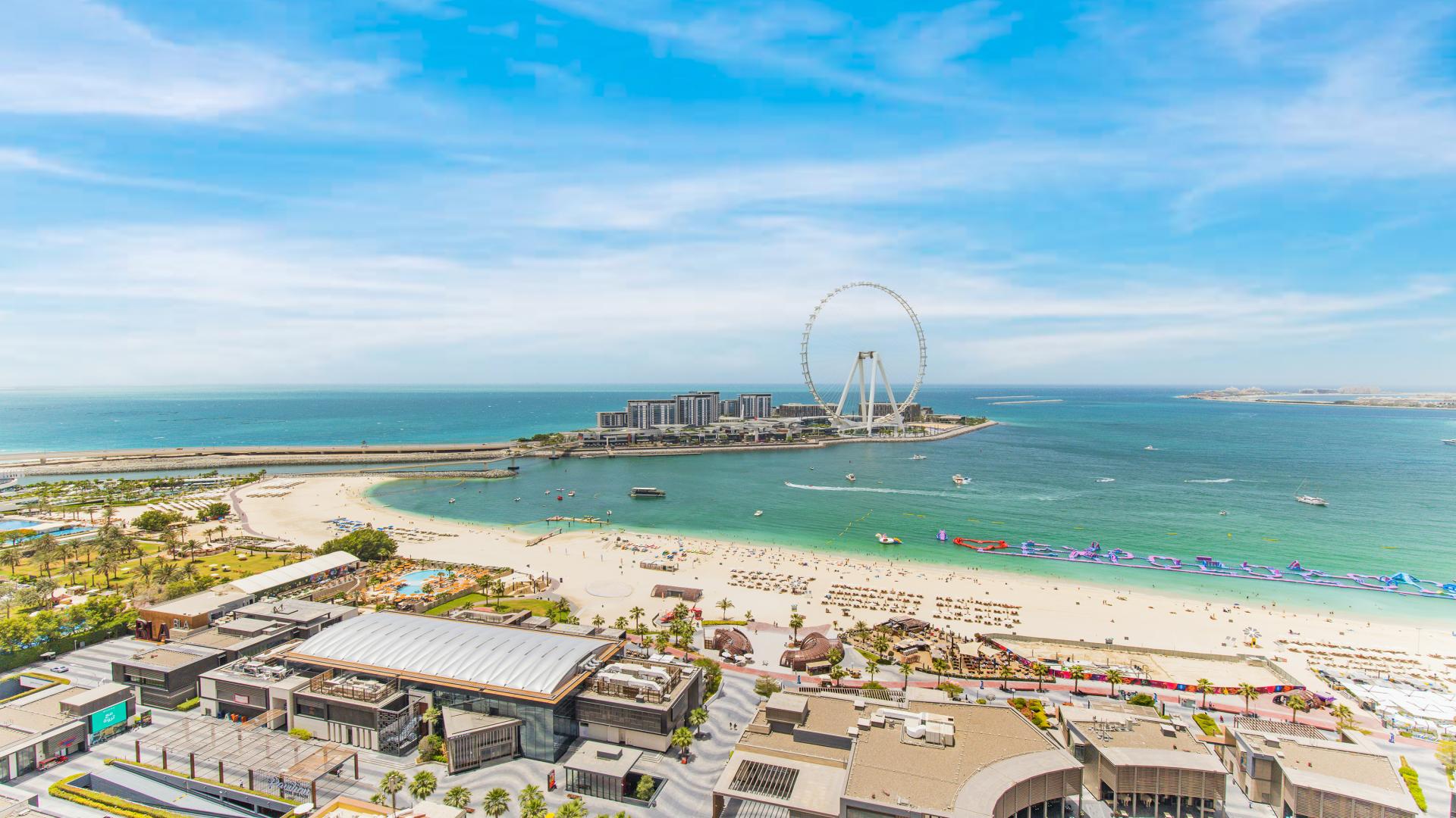 Spacious living room in furnished JBR apartment with sea view, blue sofas, dining area