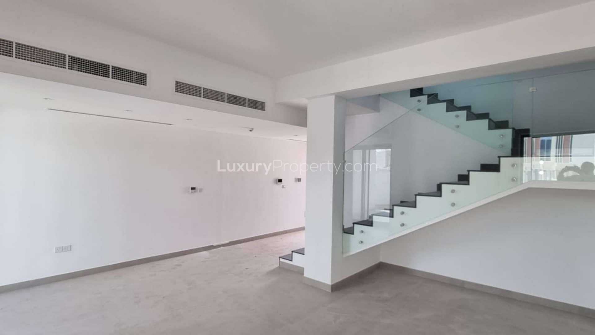 "Spacious living area with staircase in Rukan 2 townhouse, Dubai Land, available for rent.",Spacious living area with modern staircase in Rukan 2 townhouse, Dubai Land