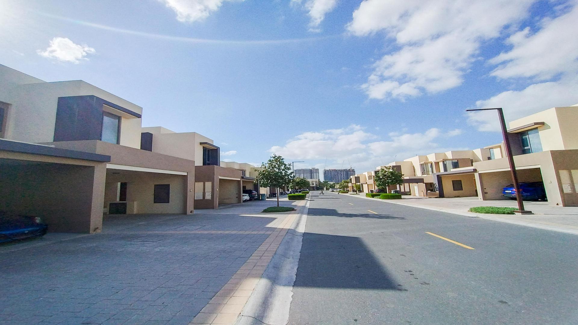 "Modern Maple 2 townhouse exterior in Dubai Hills Estate, available for rent, LP47598.",Street view of Maple 2 townhouses in Dubai Hills Estate under clear blue sky