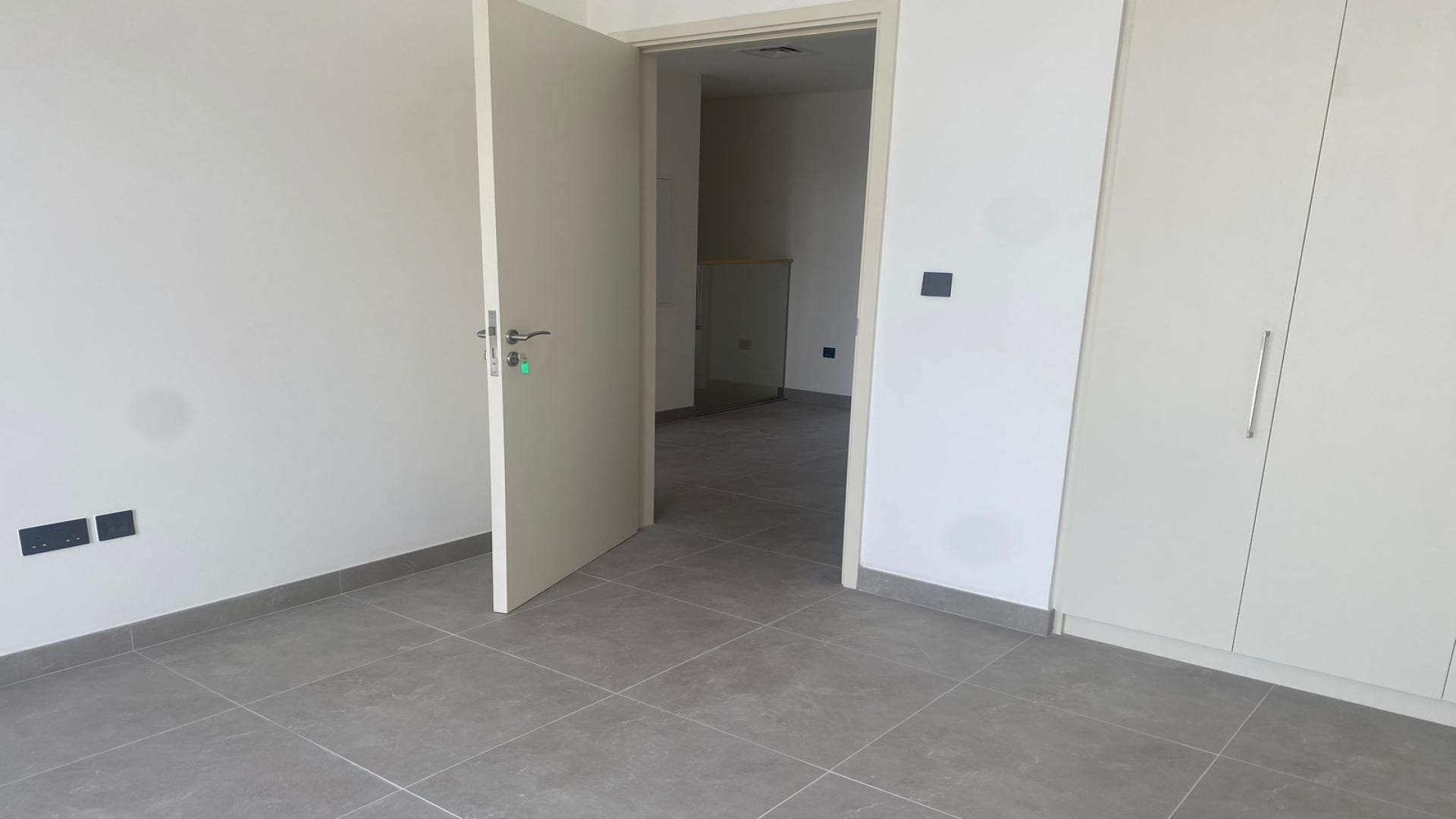 Modern kitchen and living area in Ruba townhouse, Arabian Ranches 3, with large windows