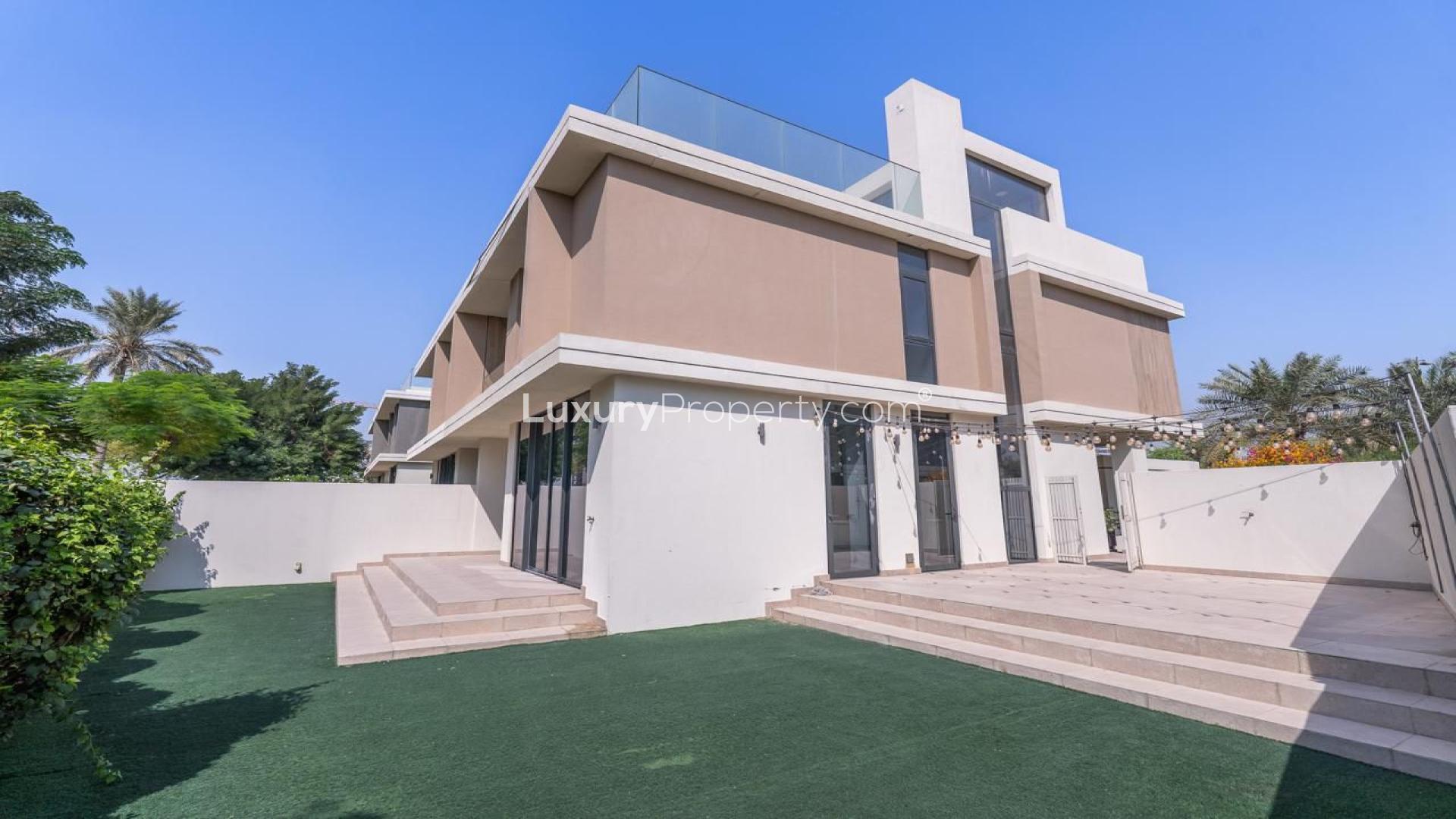 Spacious living area in 3-bedroom villa, Dubai Hills, with large windows and garden view