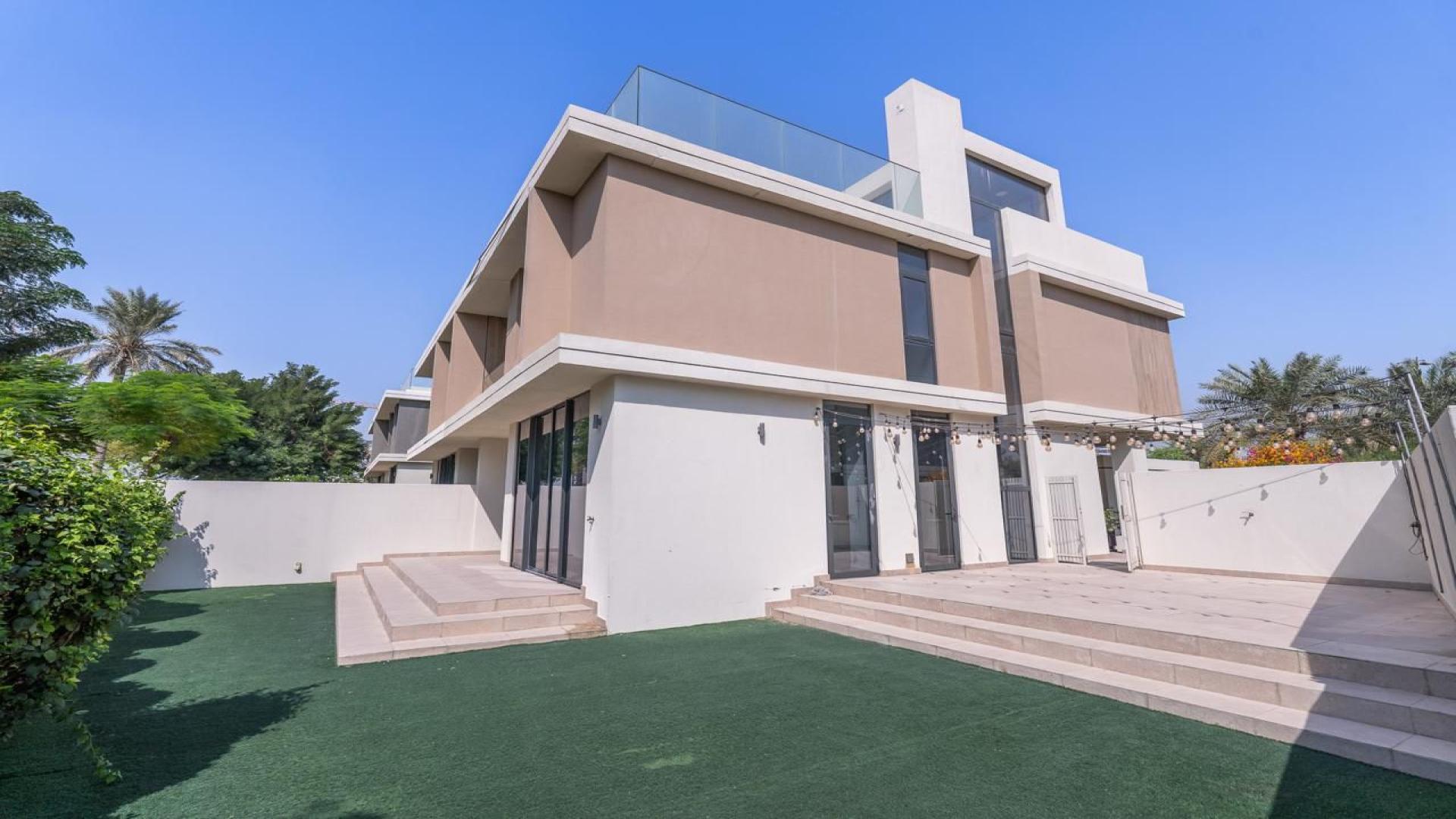 Spacious living area in 3-bedroom villa, Dubai Hills, with large windows and garden view