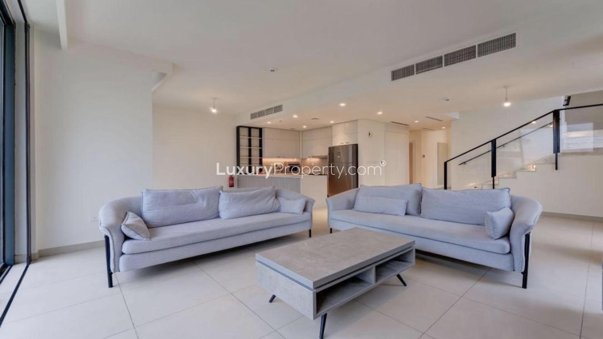 Modern living room in Dubai Hills townhouse with garden view and large windows