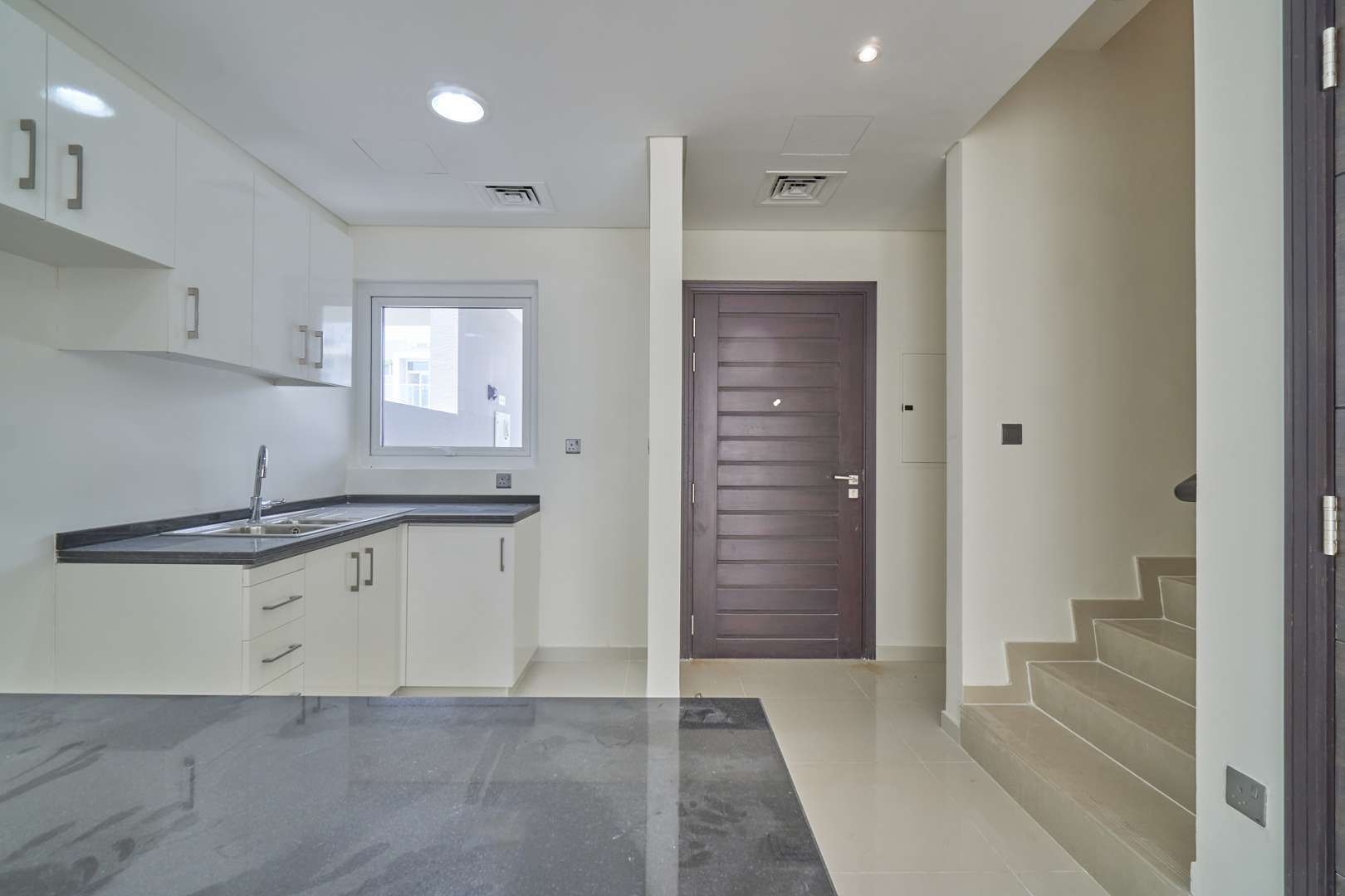 Modern 3-bedroom townhouse exterior in Albizia, Damac Hills 2, with spacious driveway and balcony
