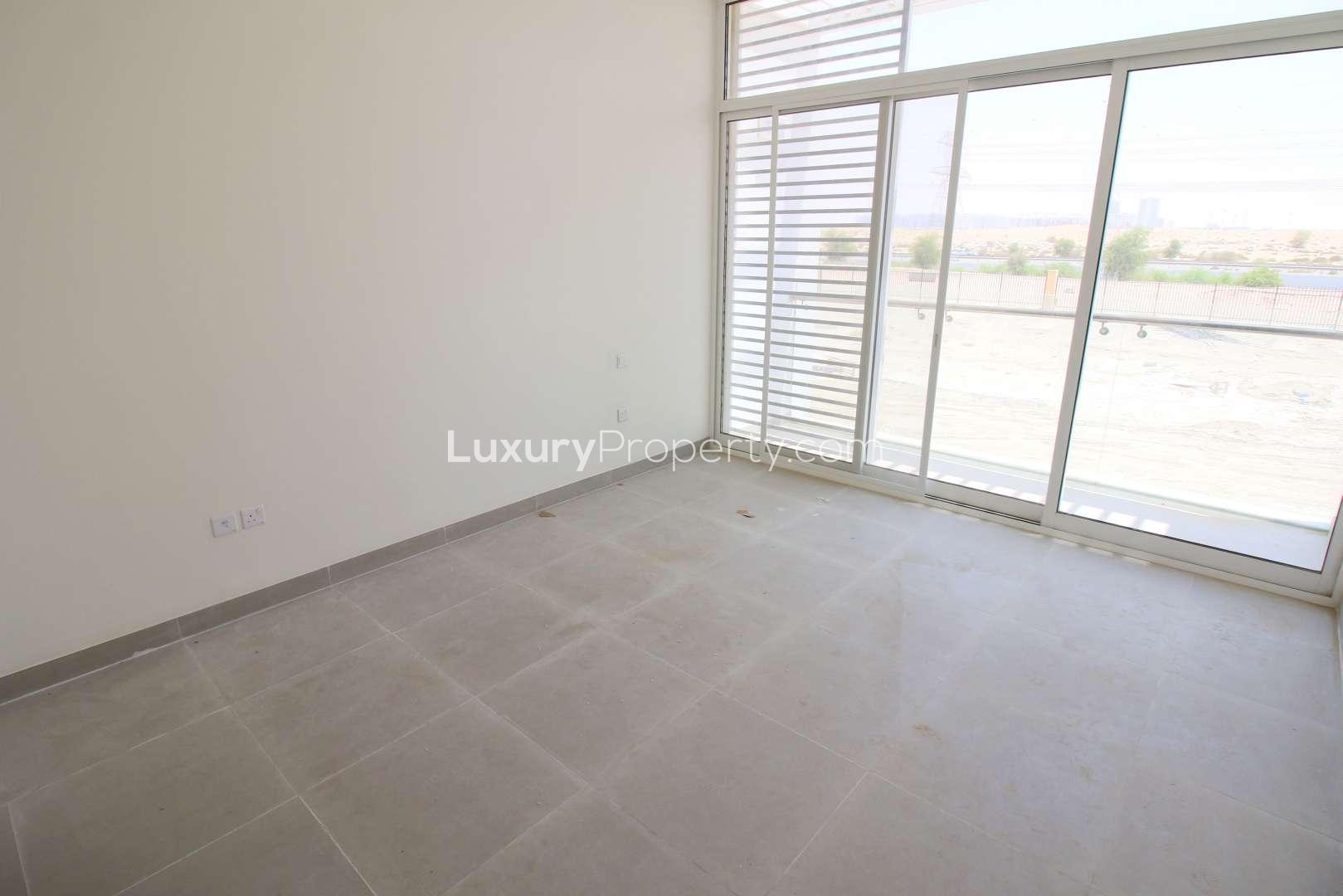 Bright living room in 3-bed Arabella Townhouse, Mudon, with large windows and tiled floor