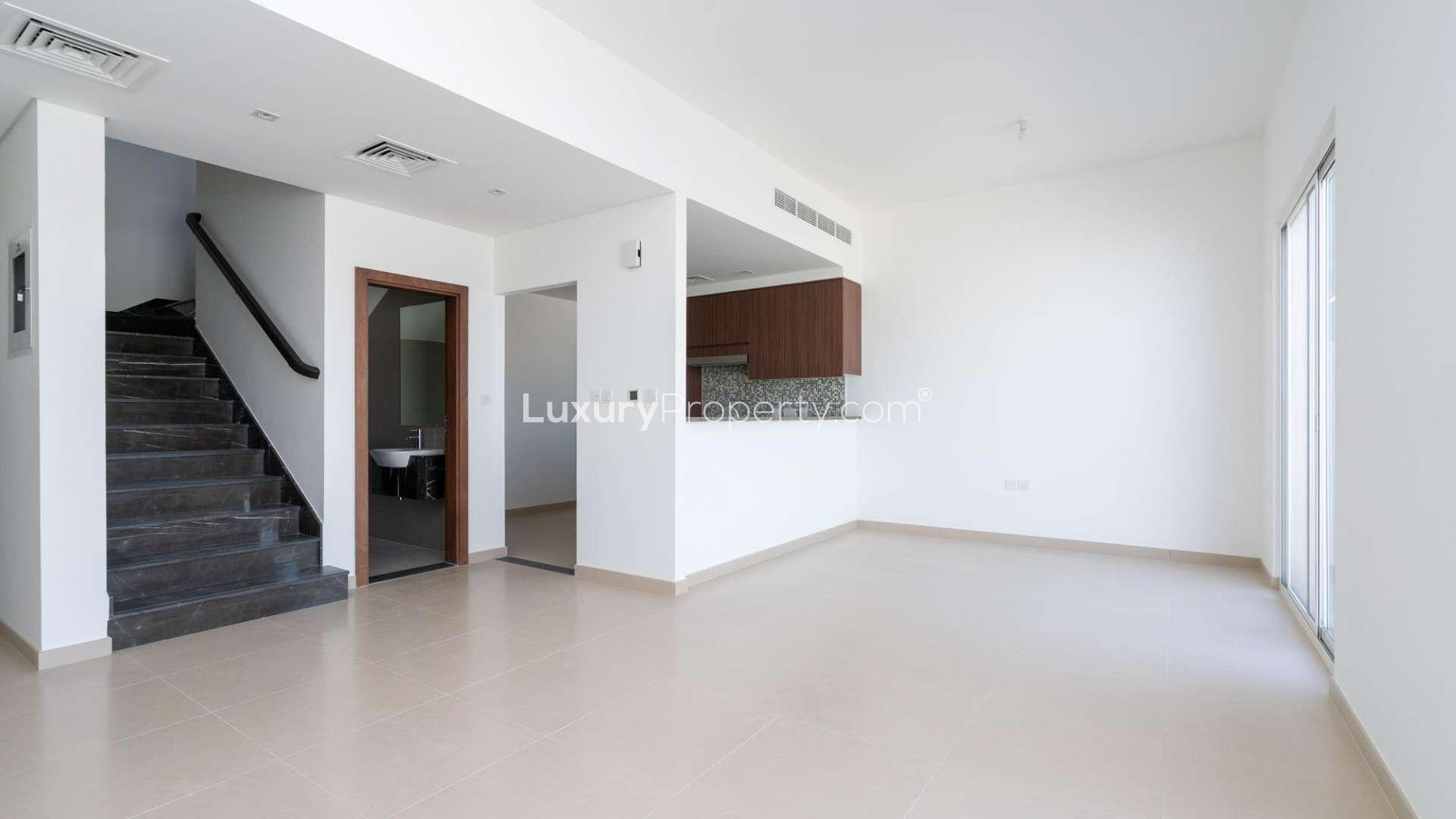 Charming three-bedroom townhouse exterior in Arabella, Mudon, featuring modern design and carport