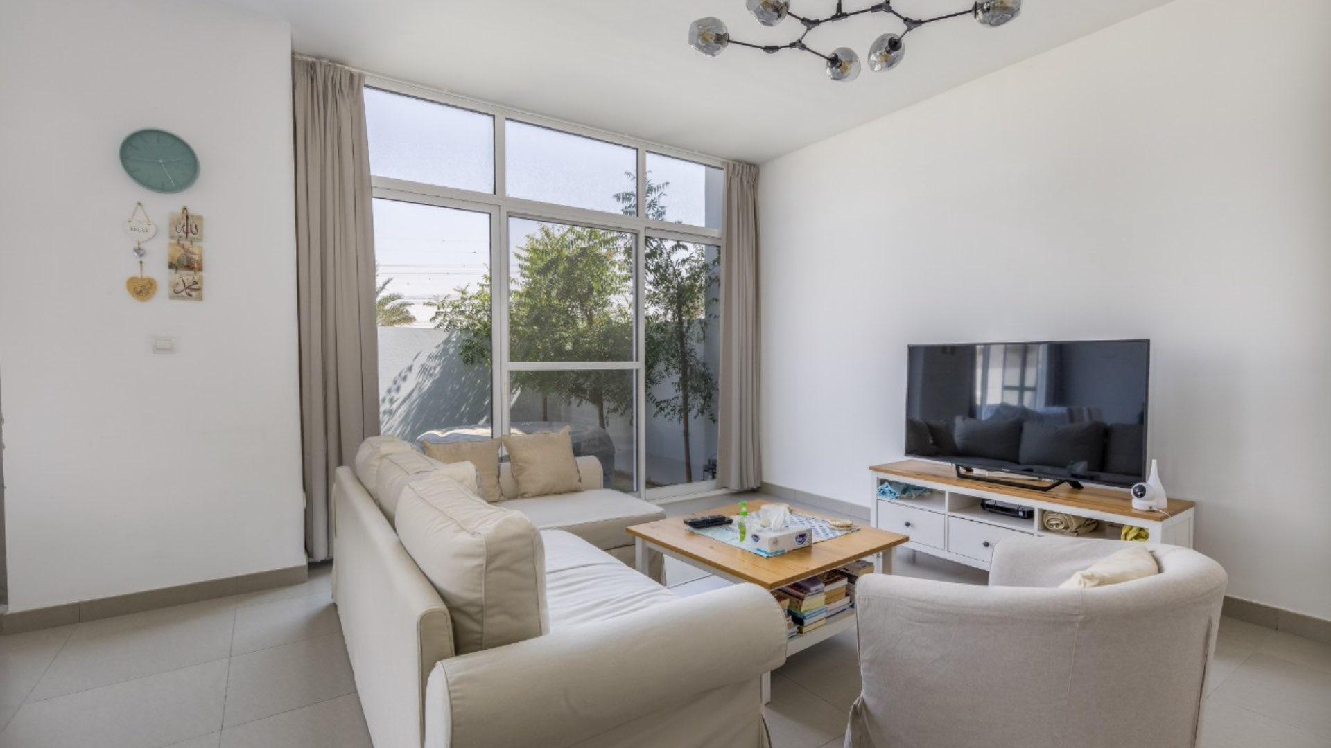 Spacious living area in 3-bedroom townhouse, Arabella, Mudon, with modern furnishings and garden view