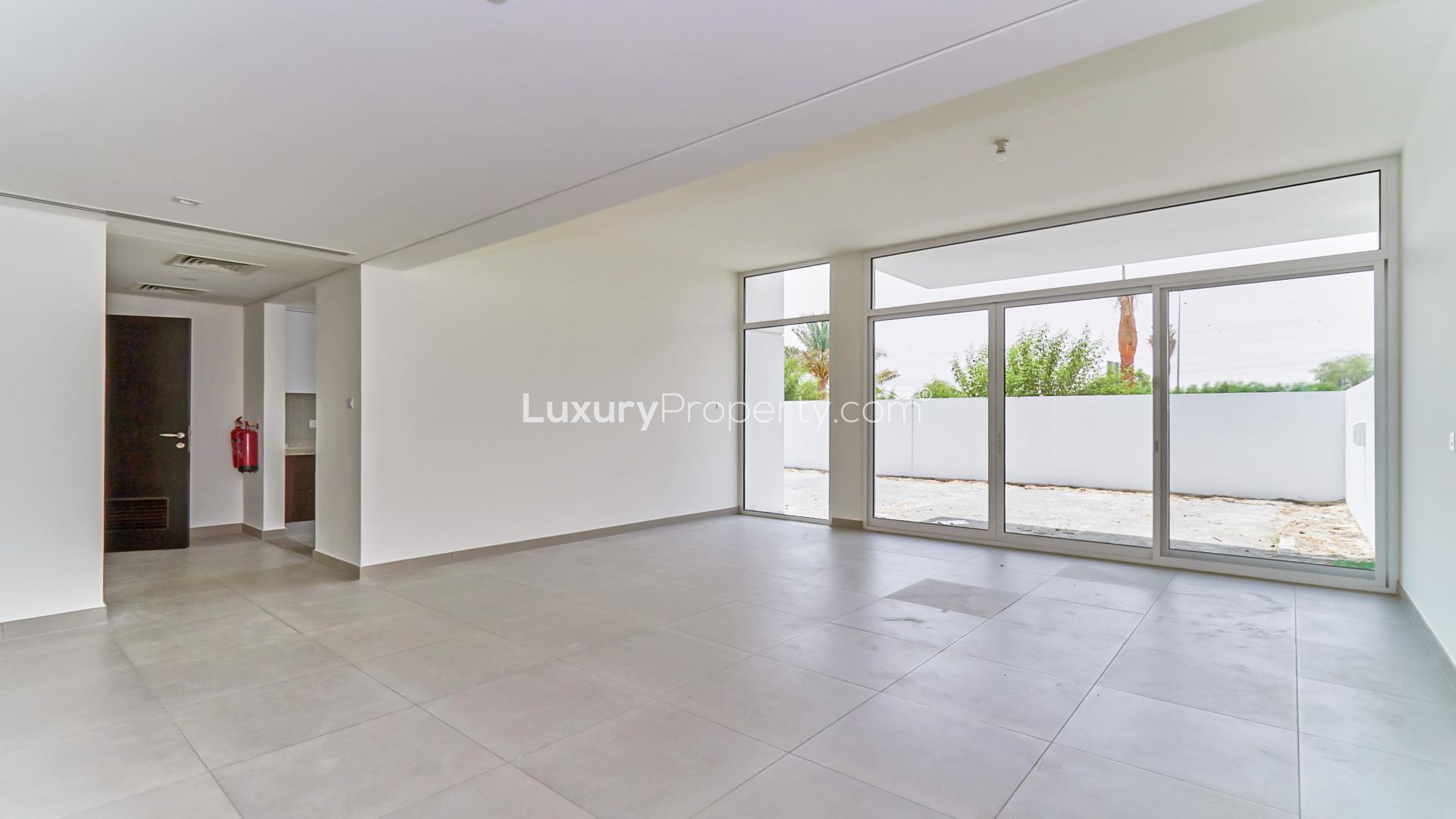 Spacious living room in Arabella Townhouse, Mudon with large windows and patio view