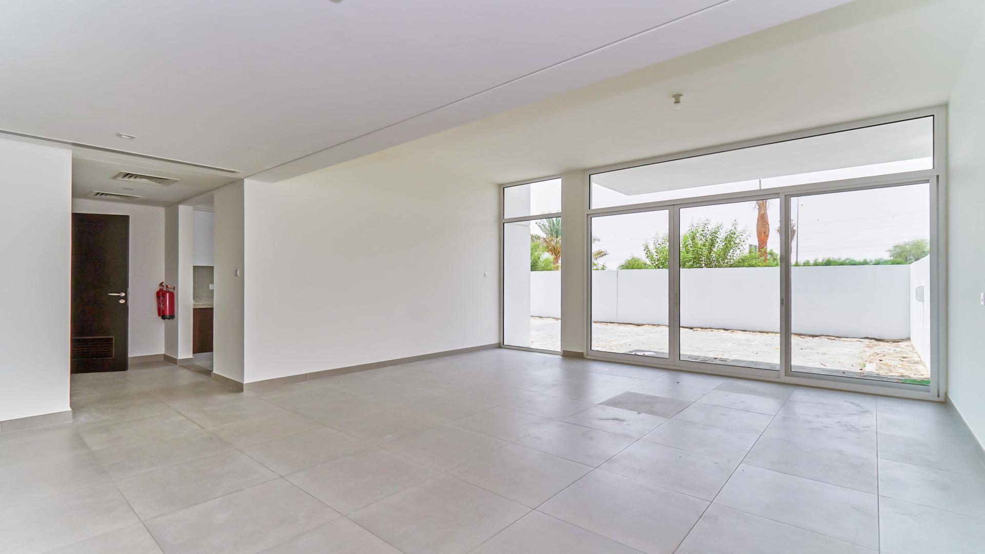 Spacious living room in Arabella Townhouse, Mudon with large windows and patio view