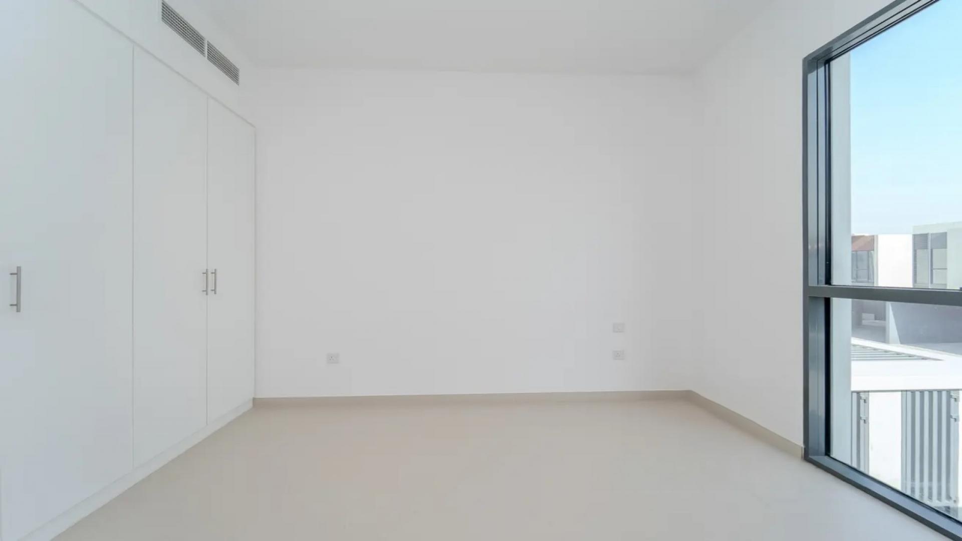 Open-plan living area in Cherrywoods townhouse, Dubailand, featuring large windows and modern kitchen