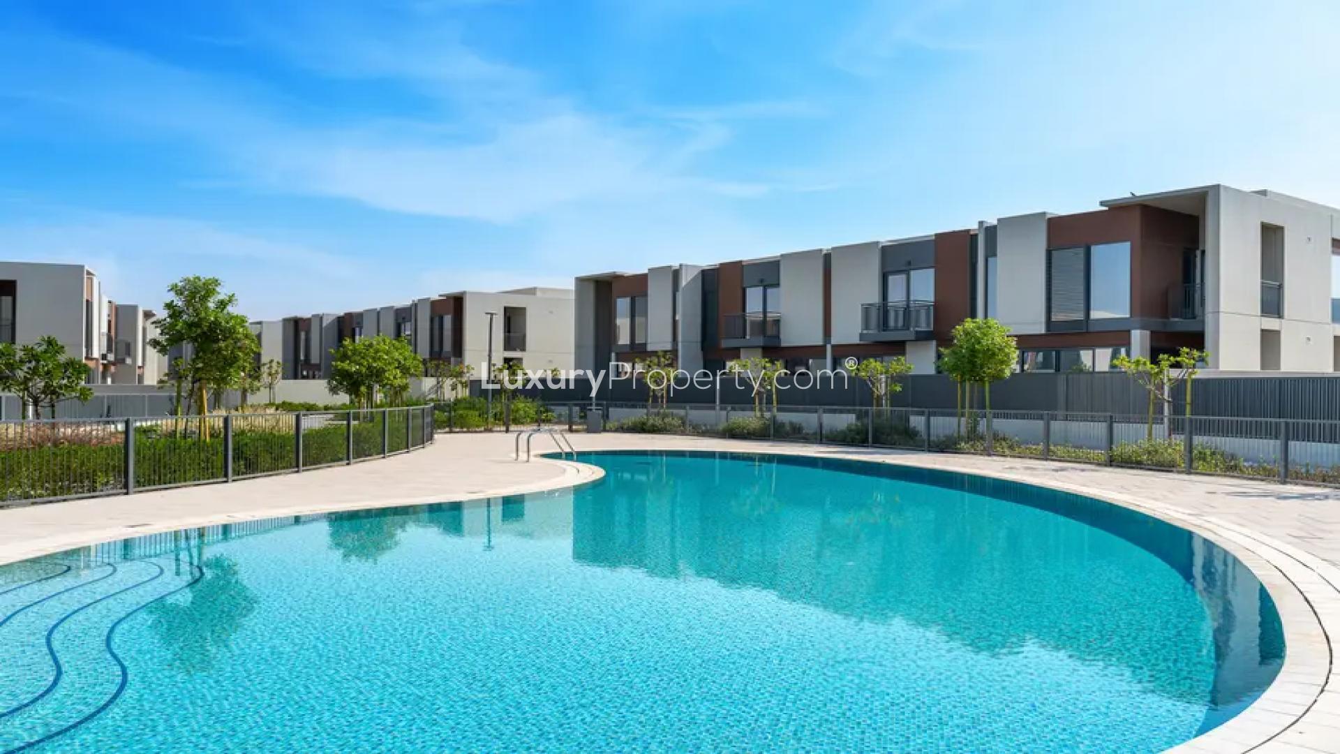 Alt text: "Bright bedroom with large window in Cherrywoods townhouse, Dubailand for rent.",Modern Cherrywoods townhouse with pool view in Dubailand, available for rent