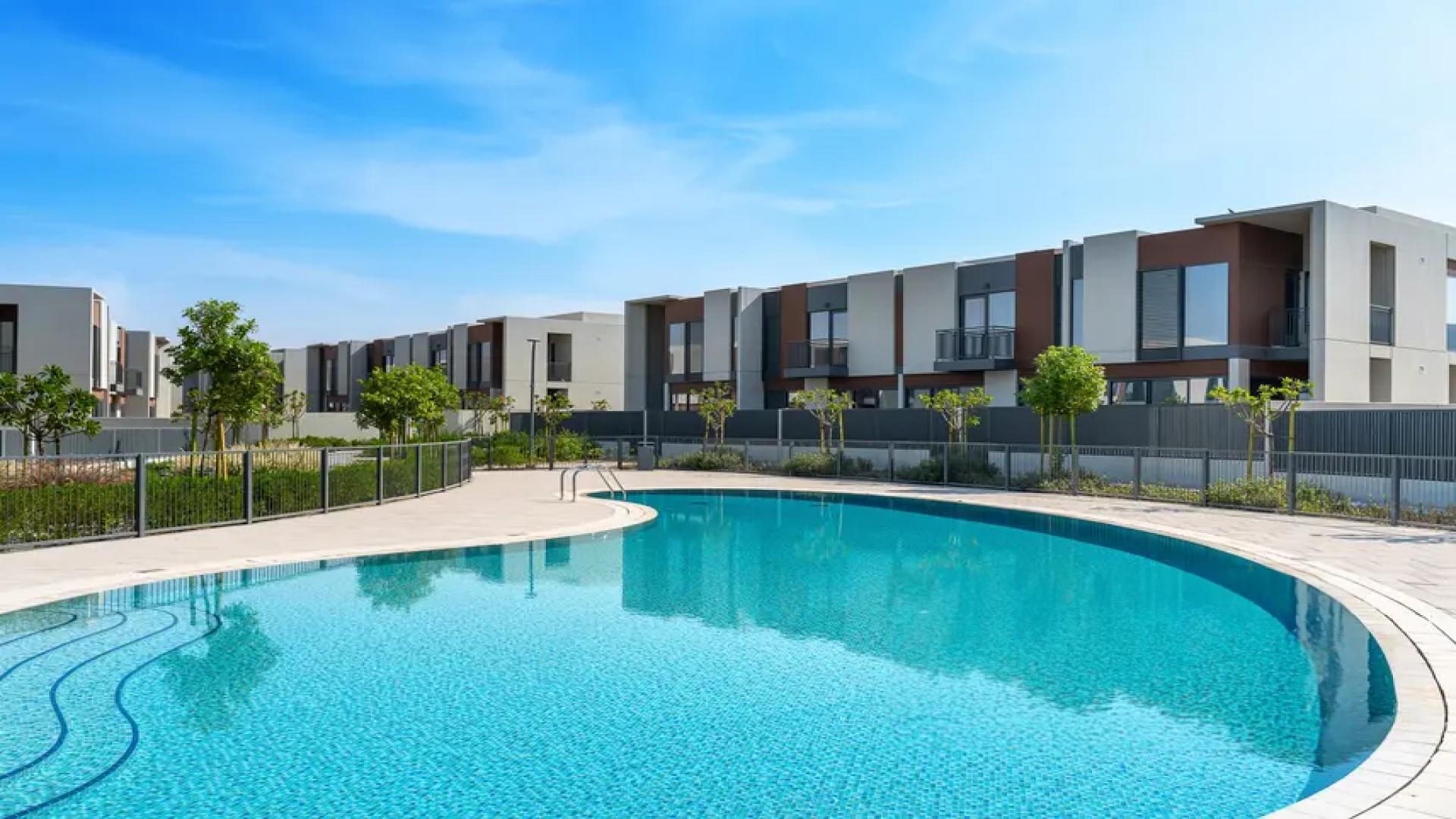 Alt text: "Bright bedroom with large window in Cherrywoods townhouse, Dubailand for rent.",Modern Cherrywoods townhouse with pool view in Dubailand, available for rent