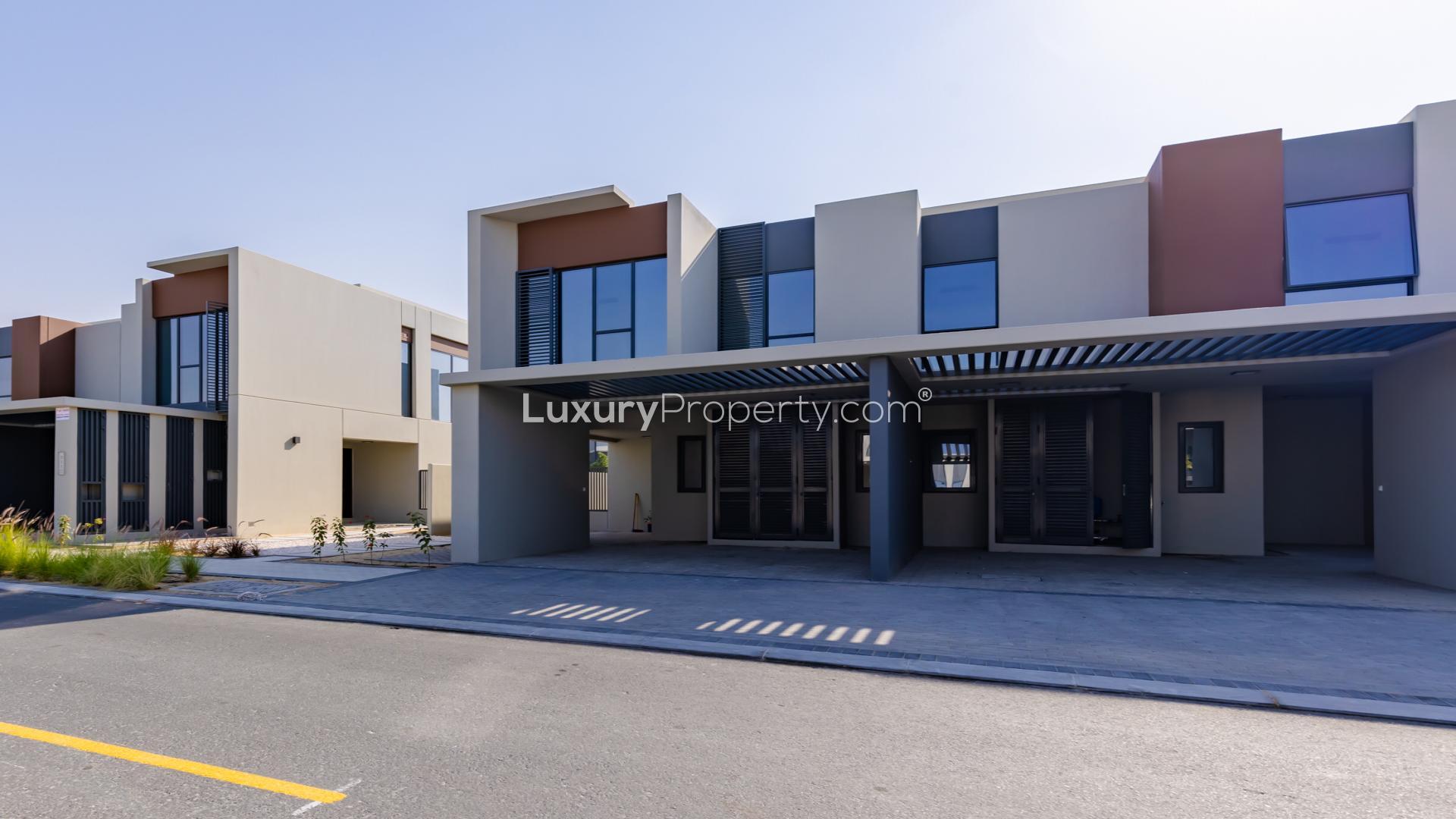 Modern kitchen in Cherrywoods townhouse, Dubai Land, with sleek white cabinetry and marble accents