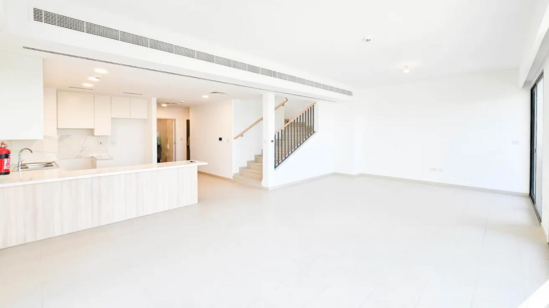 Modern open-plan living area in Cherrywoods townhouse, Dubai Land, with bright spacious design