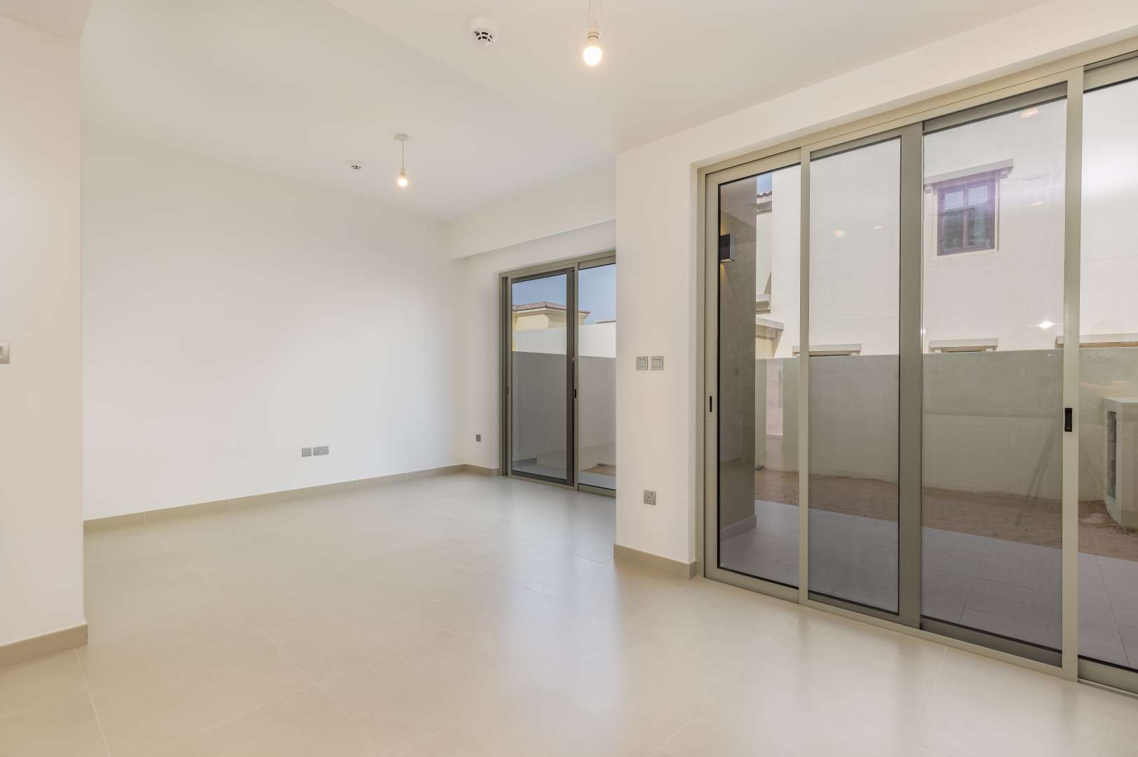Bright living room with sliding glass doors in Camelia townhouse, Arabian Ranches 2