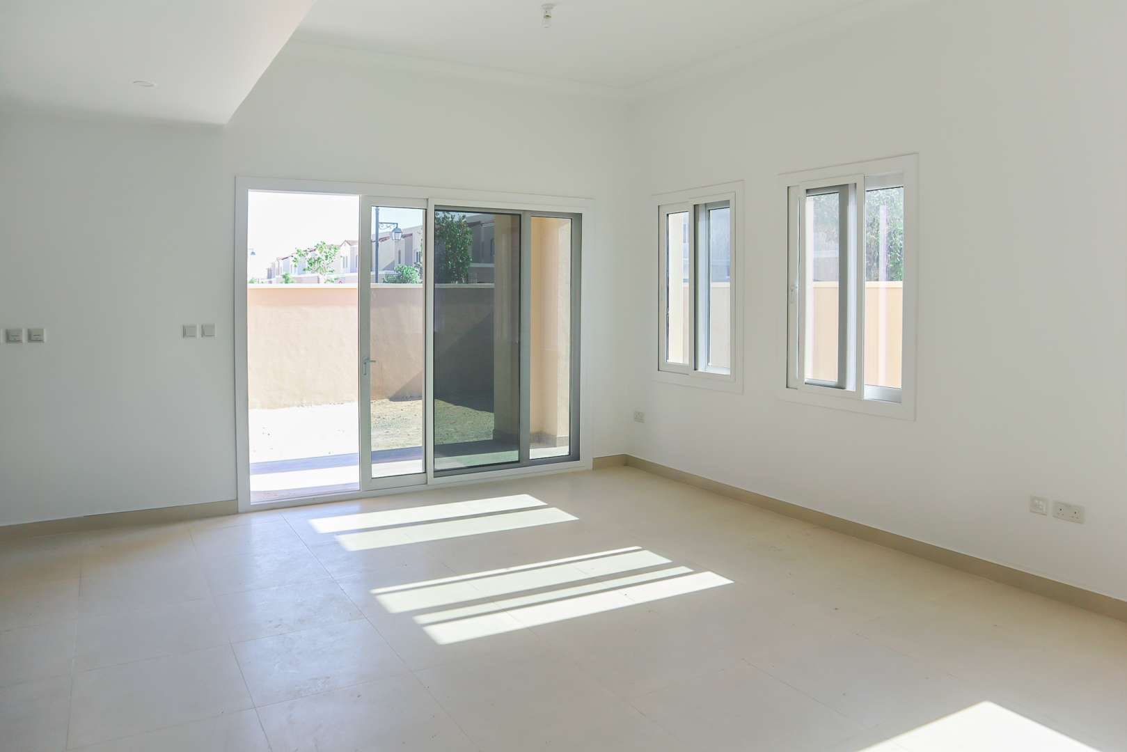 Bright 3-bedroom townhouse exterior in Casa Viva, Serena, Dubailand, with driveway and garden