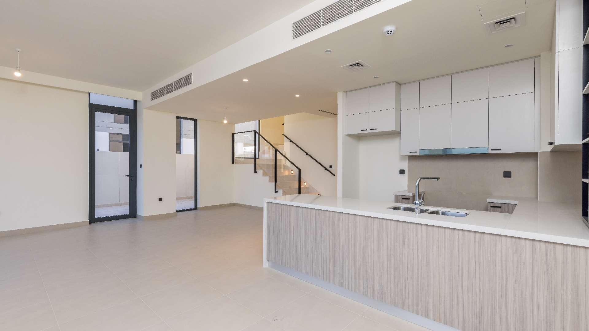 "Spacious living area in brand new villa, Dubai Hills Estate, Golf Grove community.",Modern open-plan kitchen and living area in Dubai Hills Estate villa for rent