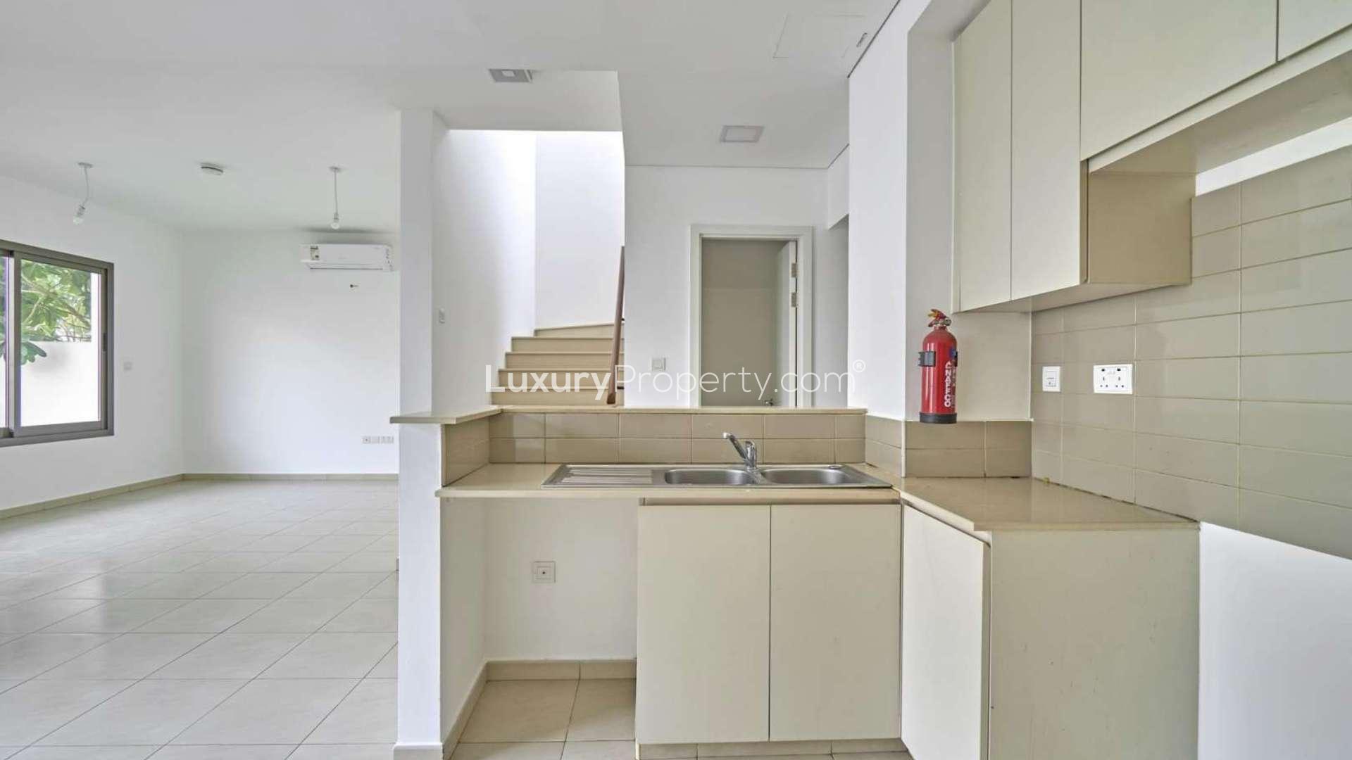 Empty room with tiled floor and large window in Town Square townhouse