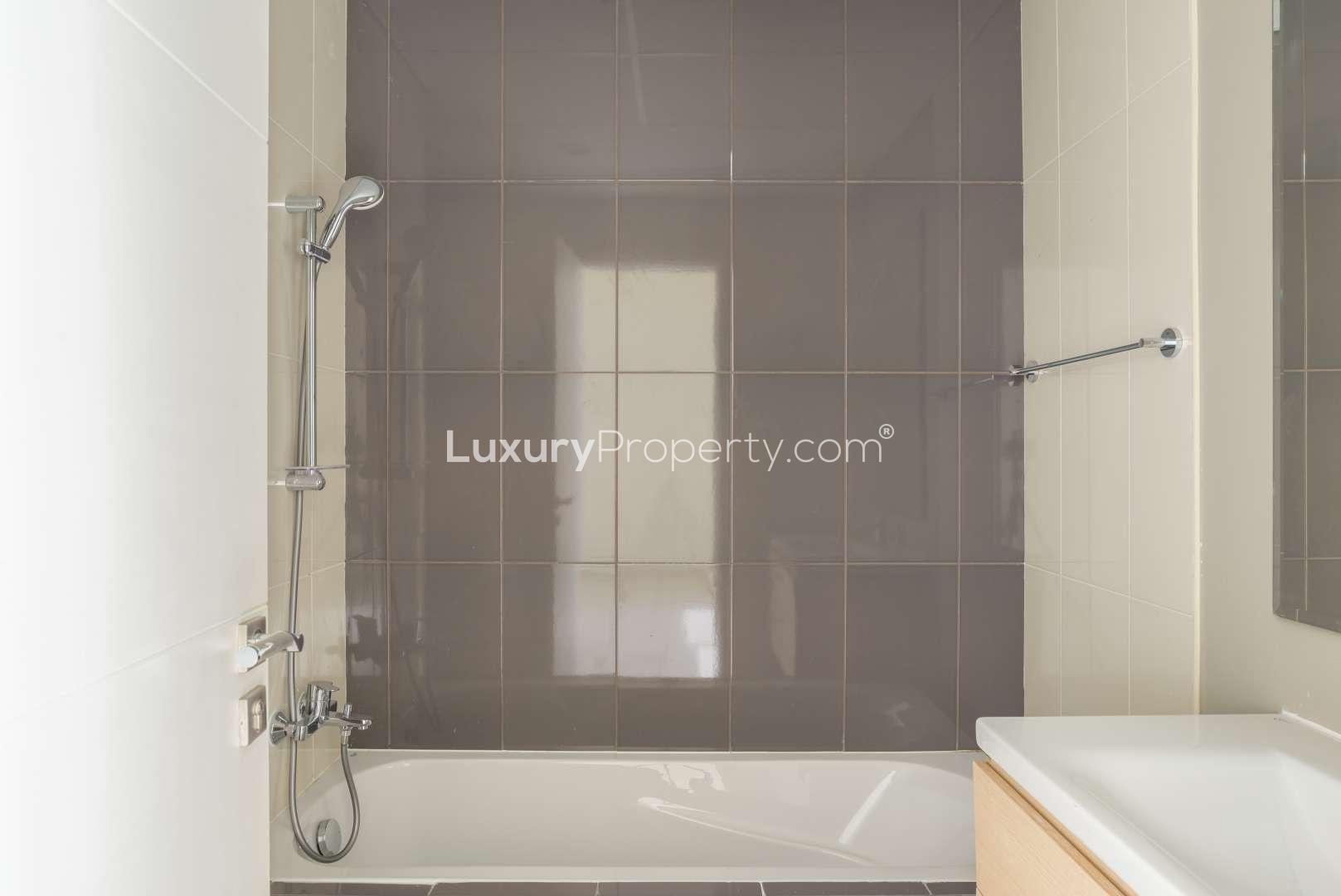 "Bright bedroom with built-in wardrobe and balcony in Damac Hills 2 townhouse for rent.",Modern bathroom in 3-bedroom townhouse, Janusia, Damac Hills 2, available for rent