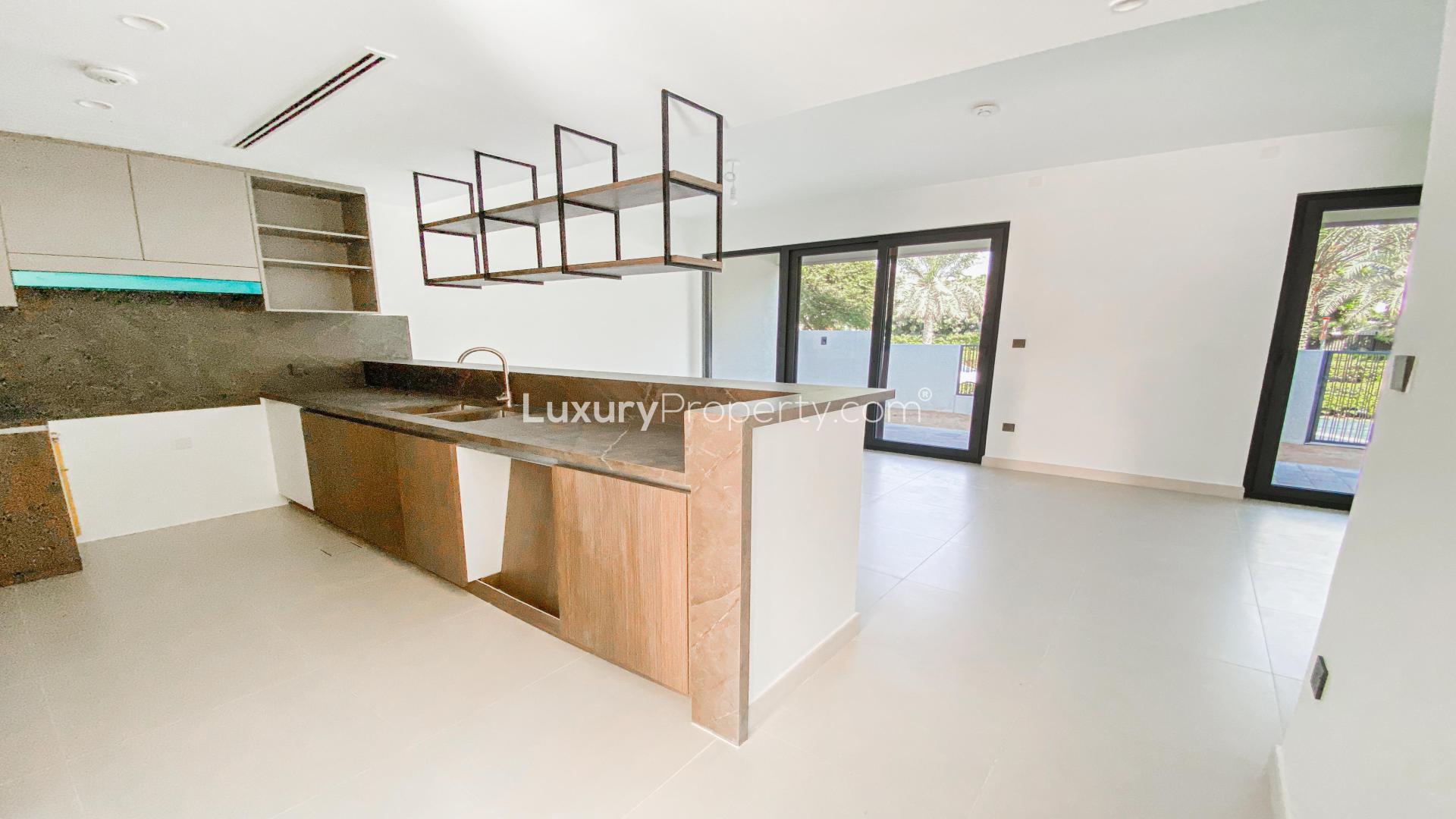 Townhouse garden view in Aura Gardens, Tilal Al Ghaf, featuring lush greenery and modern fencing