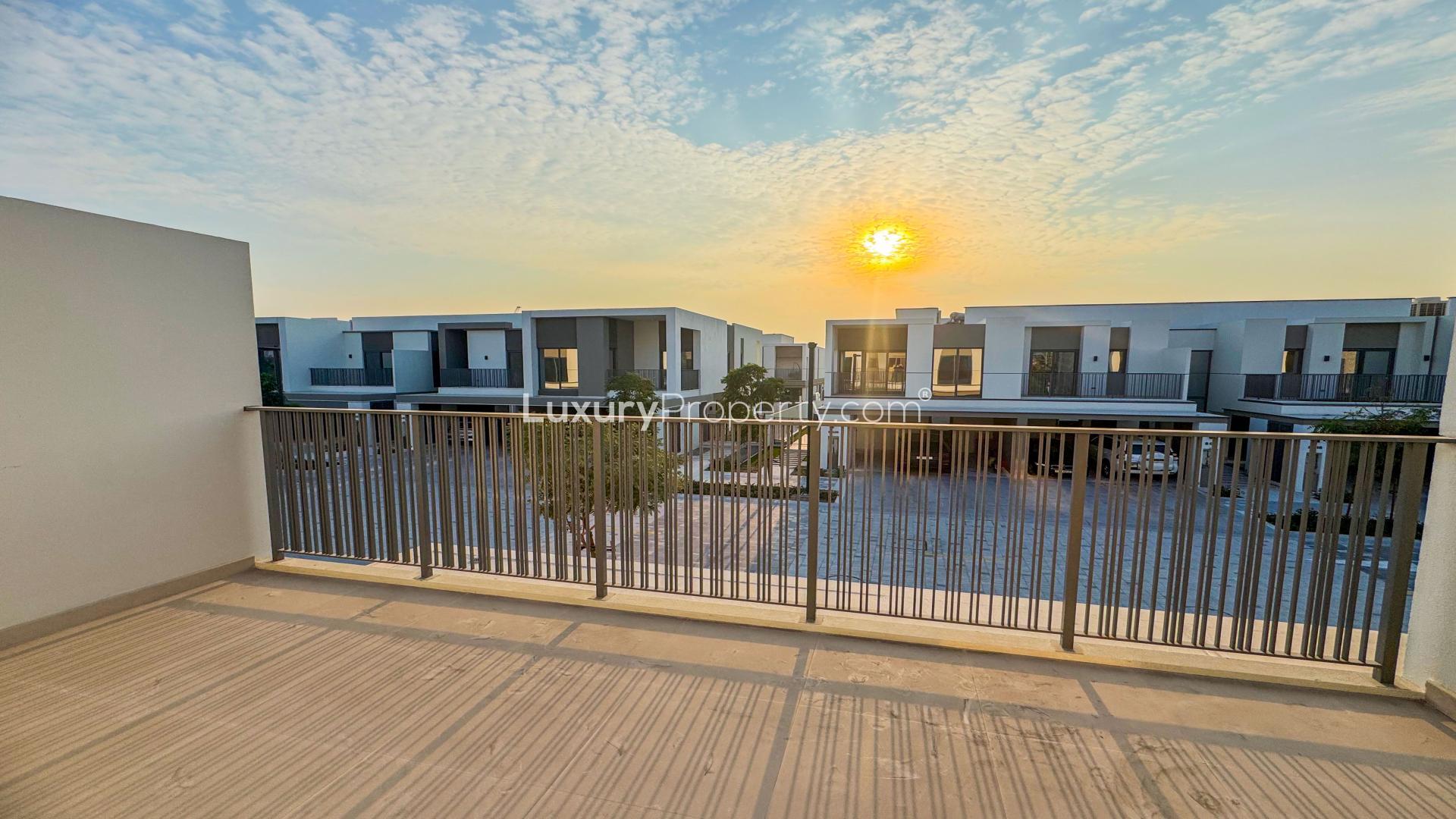 "Sunset view from Aura Gardens townhouse balcony in Tilal Al Ghaf community, for rent.",Townhouse garden in Aura Gardens, Tilal Al Ghaf, with lush lawn and flowers for rent