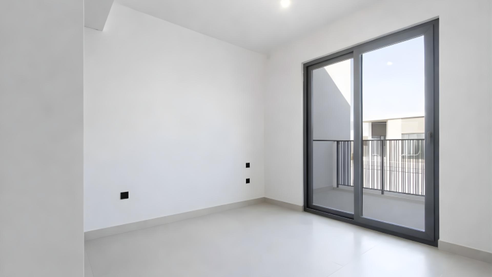 "Elegant entrance and staircase in Aura 3 townhouse, Tilal Al Ghaf rental property.",Bright bedroom with balcony access in modern 3-bedroom townhouse, Aura 3, Tilal Al Ghaf