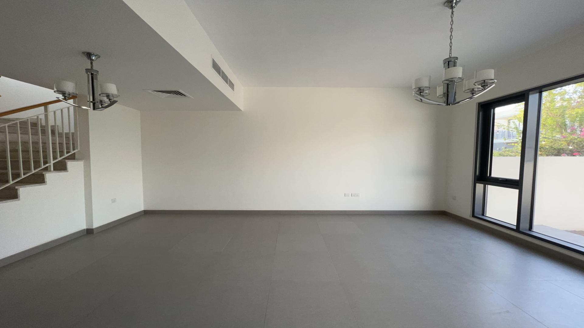 Spacious living area in Dubai Hills Estate villa with modern design and sliding doors