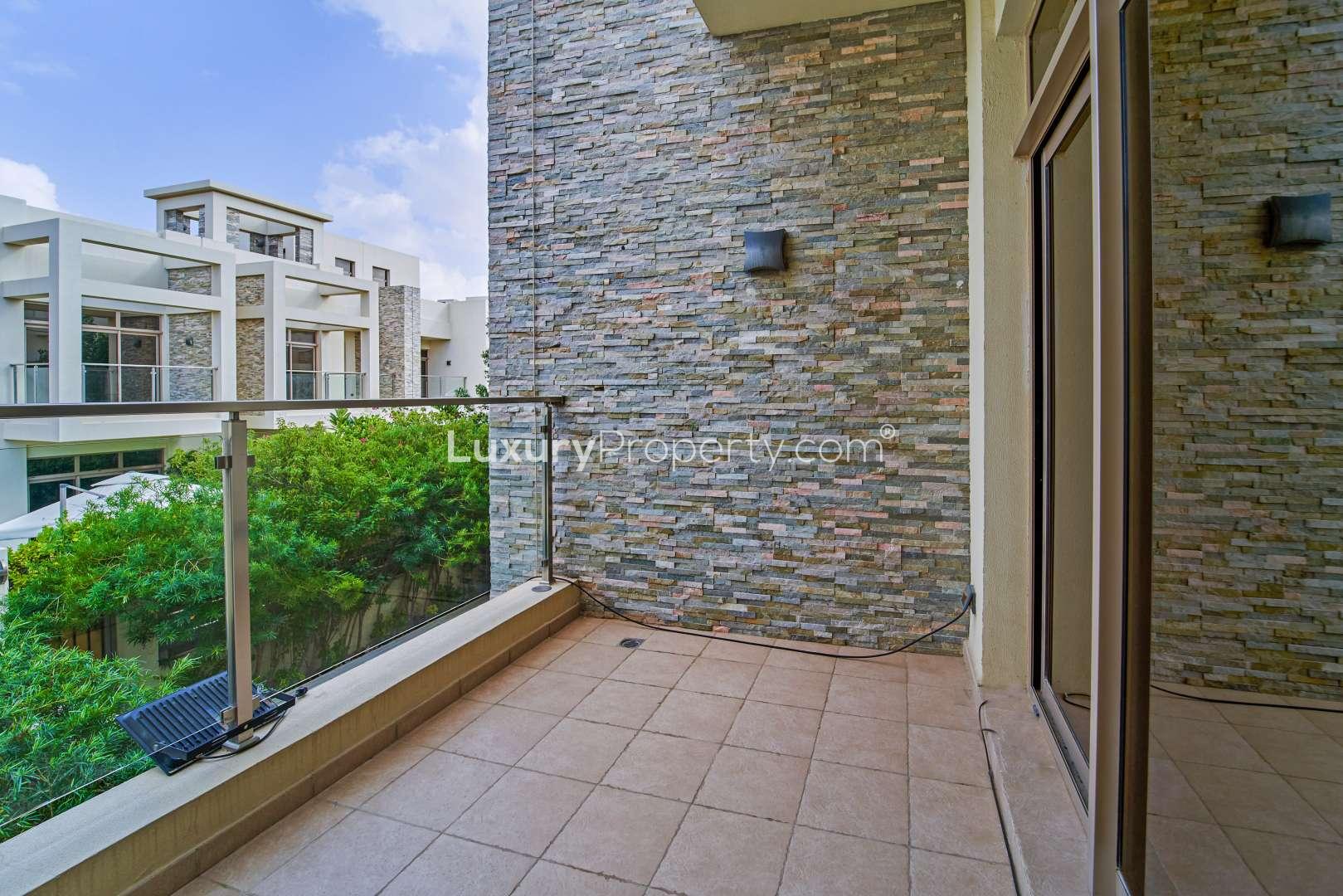 "Charming patio area in 3-bedroom townhouse, Polo Townhouses, Meydan, Dubai, with lush greenery.",Balcony view of spacious townhouse in Meydan Gated Community, Dubai, with stone wall design