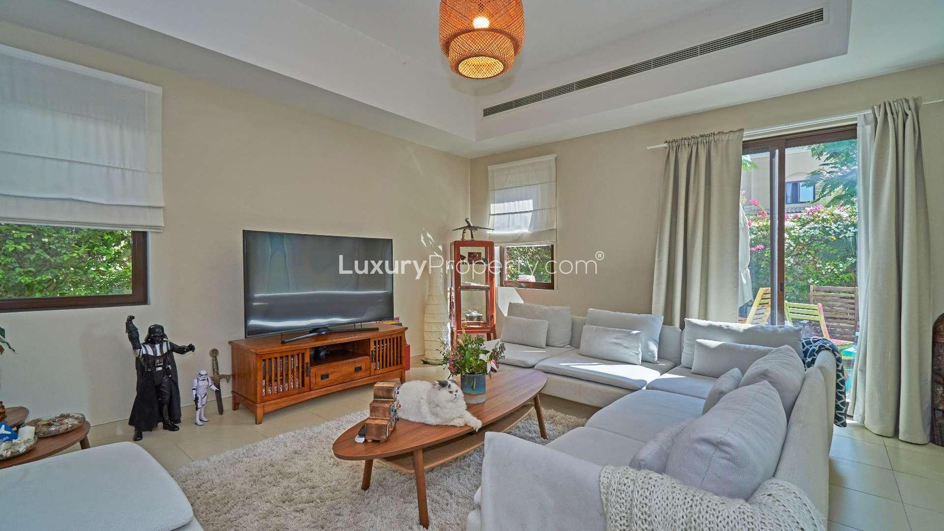 Living room in Mira townhouse, cozy seating, large TV, garden view, natural light
