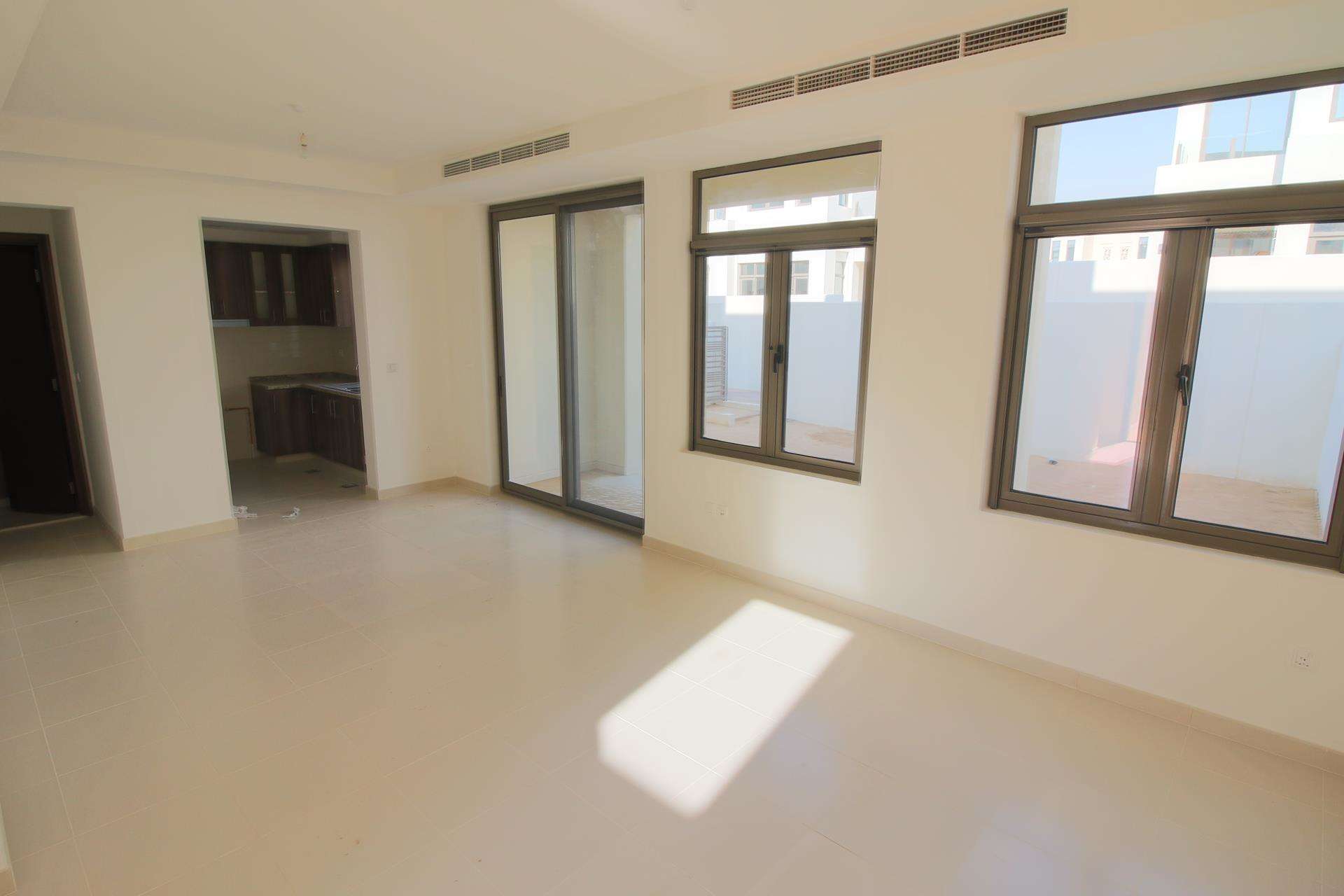 Empty room with large windows in Mira Oasis townhouse, Dubai, available for rent