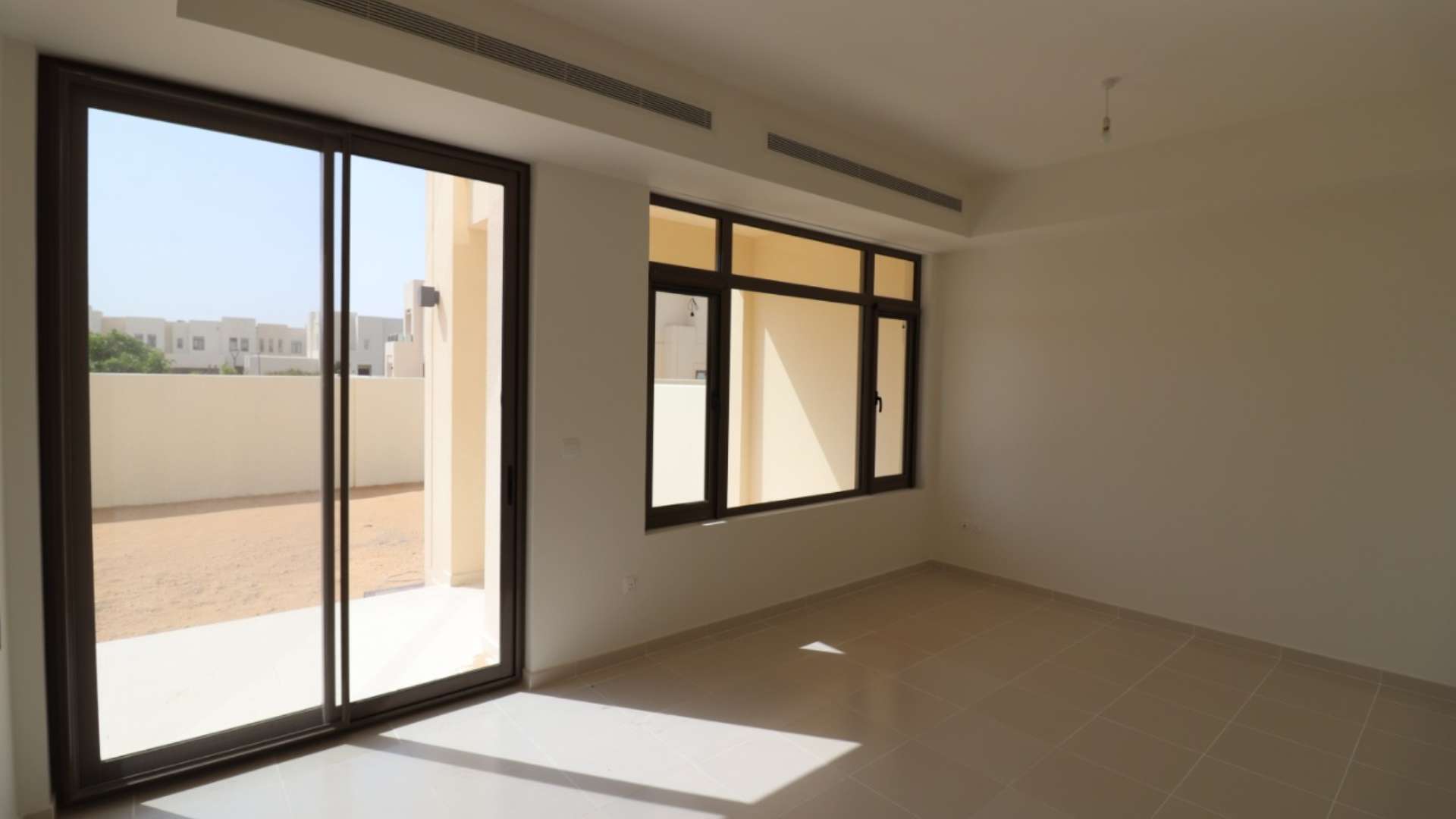 Empty living room with large windows in Mira Oasis 3 townhouse, Reem community