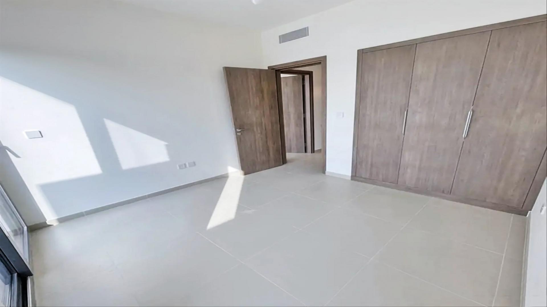 Spacious living room in Elan townhouse, Tilal Al Ghaf, with large windows and balcony