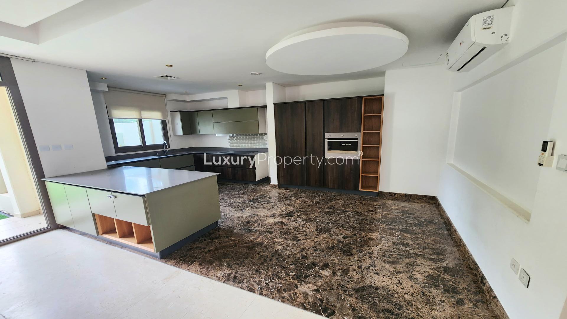 "Spacious living area in 3-bedroom Zahra townhouse, Town Square Dubai, for rent.",Modern kitchen in stylish Zahra townhouse, Town Square Dubai, with marble floors and sleek design