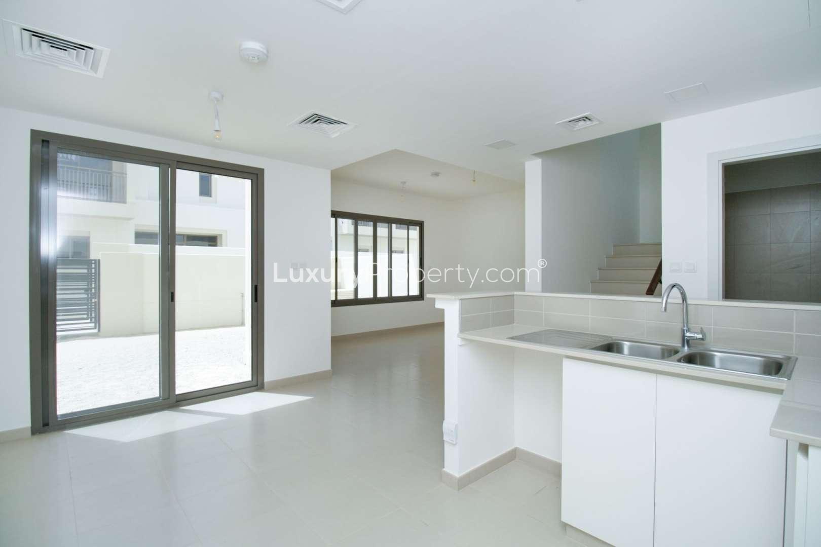 "Modern 3-bedroom townhouse exterior in Naseem, Town Square, available for rent. Family-friendly community.",Modern kitchen and living area in 3-bedroom townhouse, Naseem, Town Square for rent