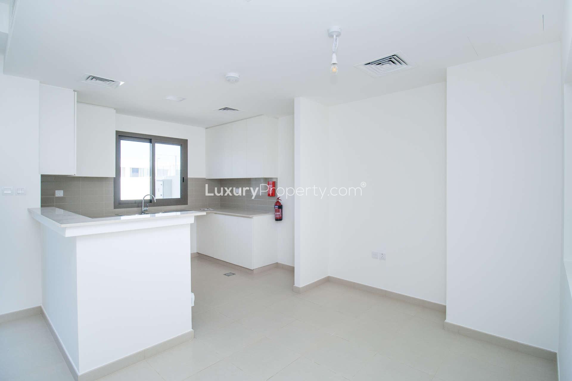 Modern living room with large windows in Noor Townhouse, Town Square rental property